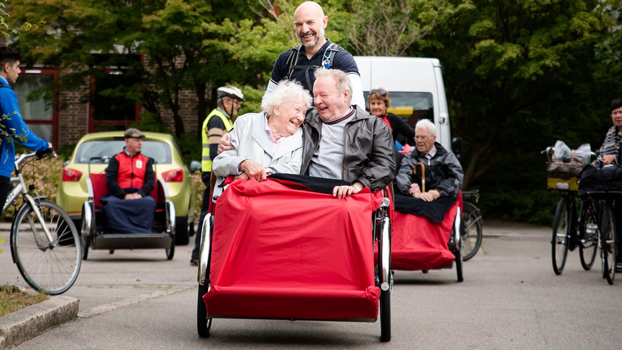 Seniorer der sidder i en rickshaw