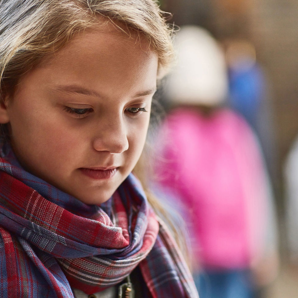 Trist pige med blikket rettet mod jorden
