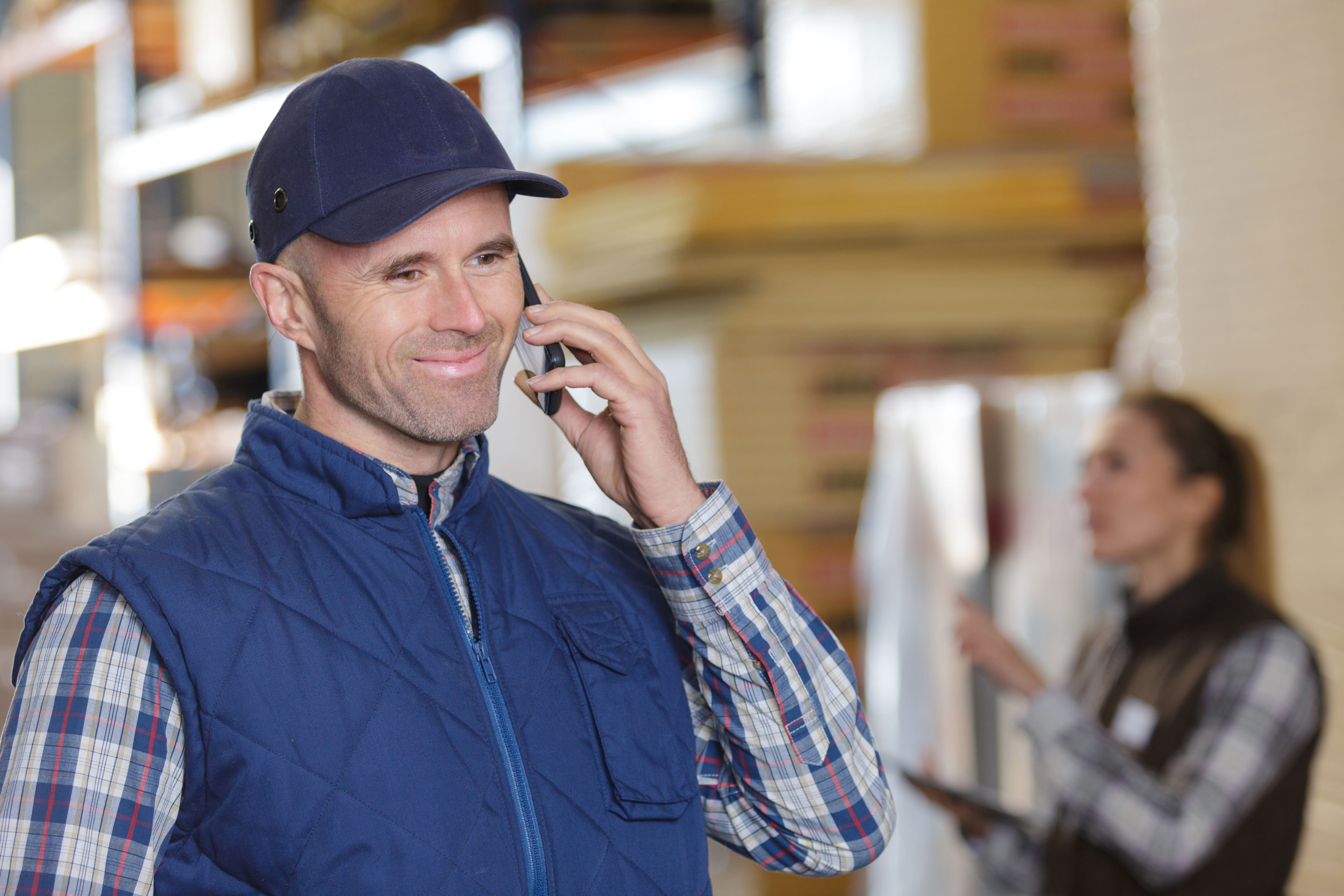 Mand på et lager der taler i mobiltelefon