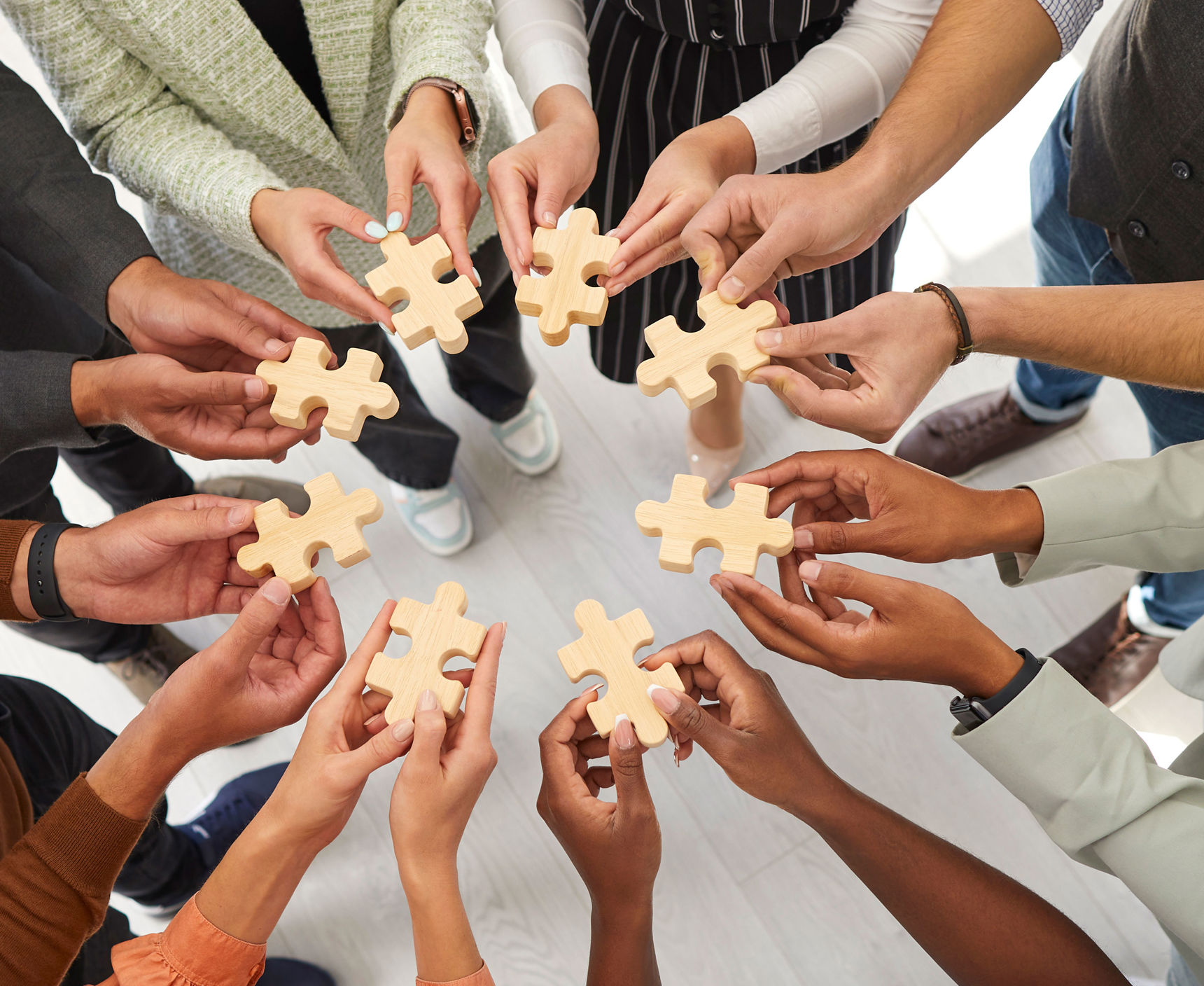 Hænder der hver holder en puslespilsbrik mod hinanden