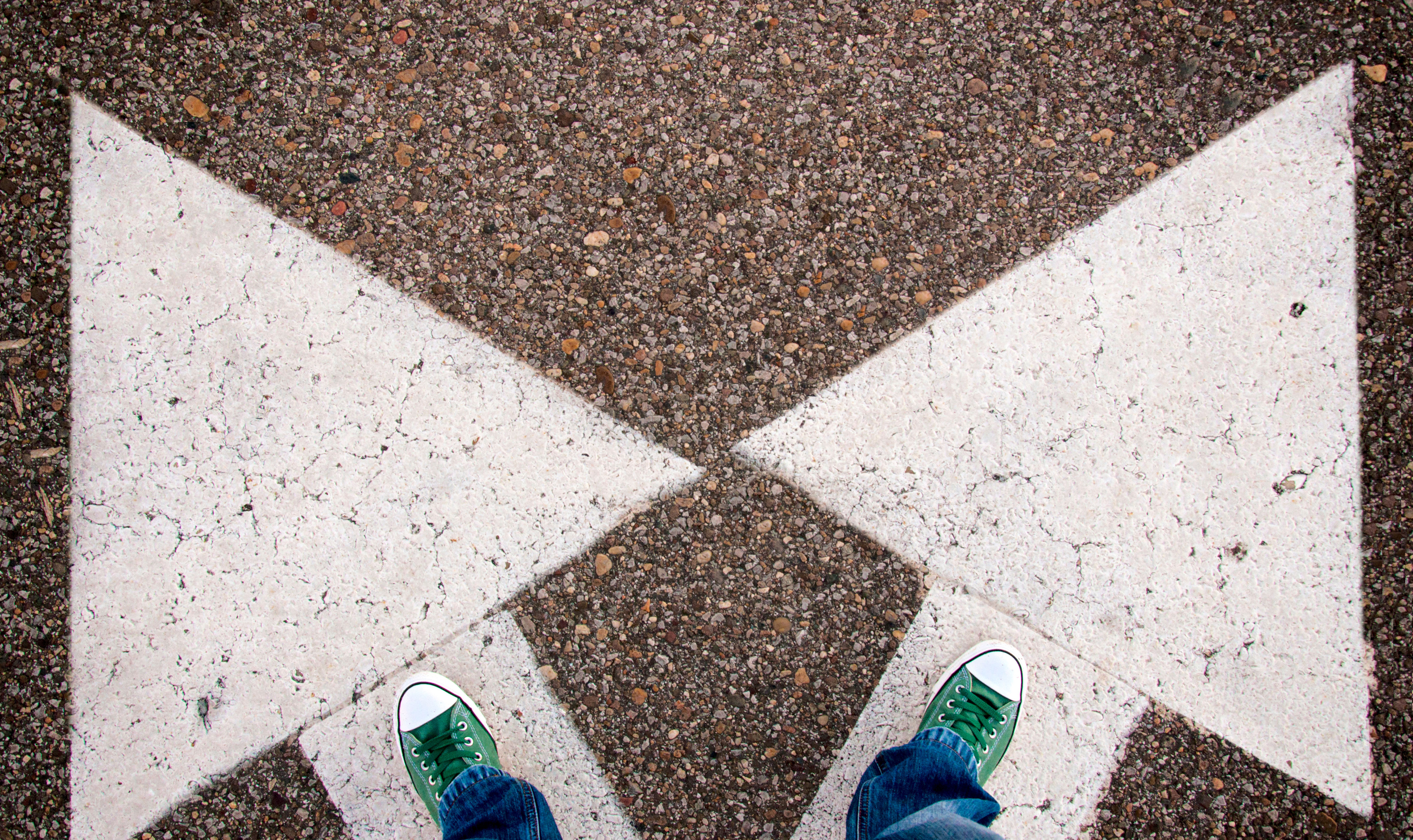 Pile på asfalt peger i to retninger ny adfærd i livet nye valg ny retning ny kurs