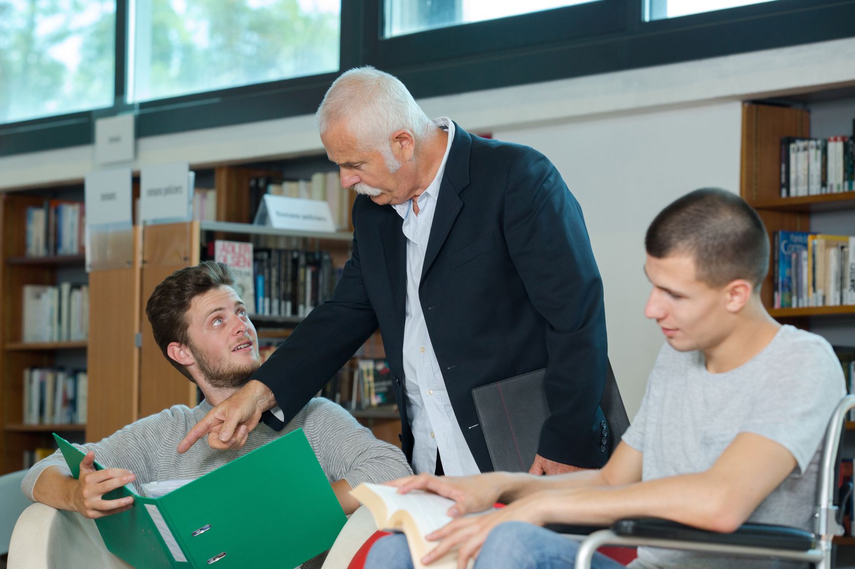 Tre mænd der kigger i bøger