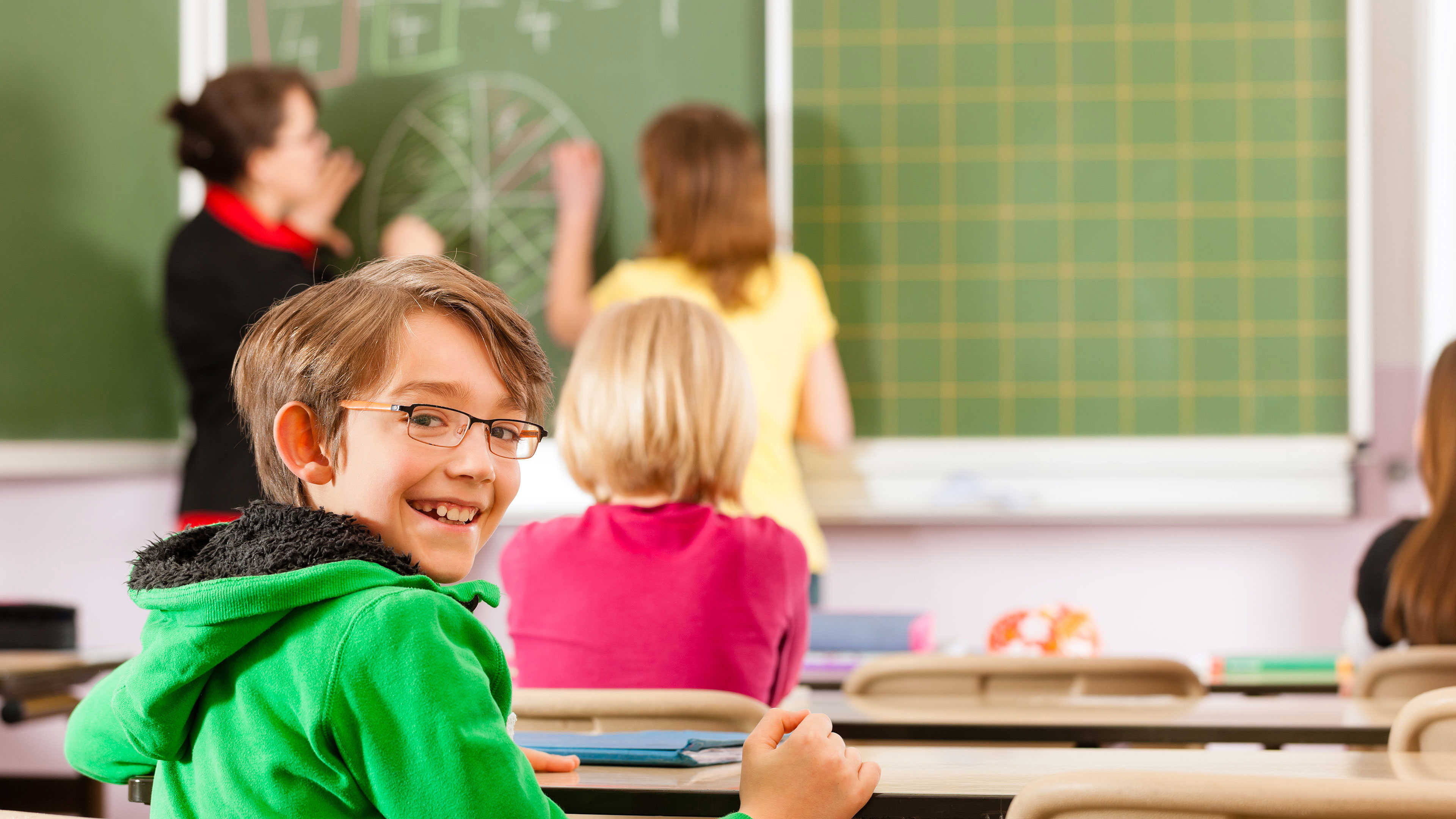 En smilende skoleelev i en skoleklasse