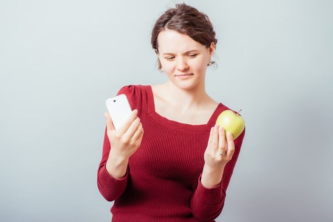Kvinde med telefon og æble