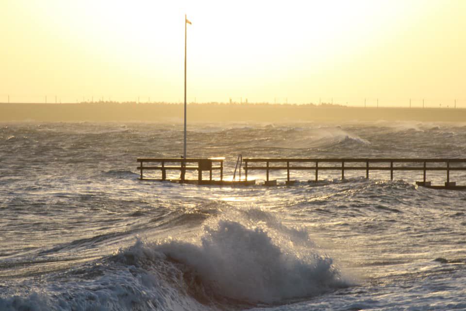 En badebro med høje bølger og skumsprøjt