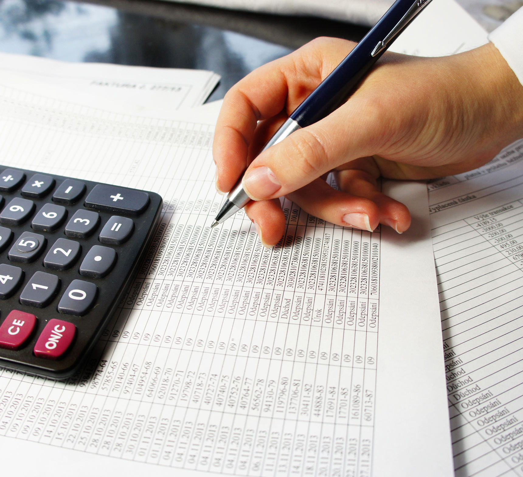 Hånd med kuglepen der laver regnskab