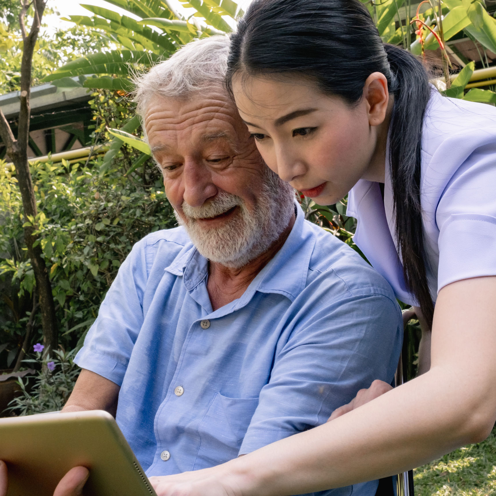 Kvinde med ældre mand der kigger på iPad