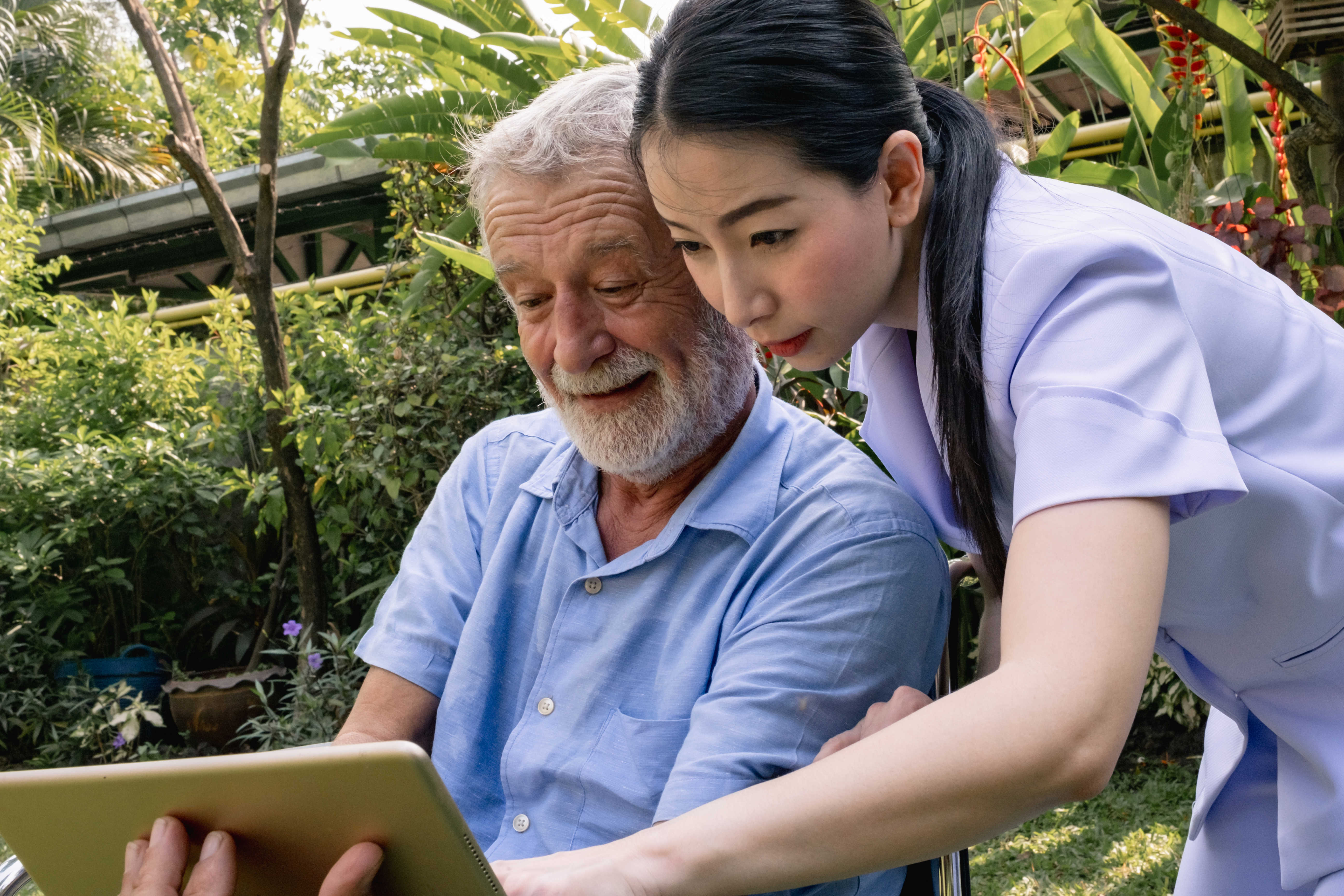 Kvinde med ældre mand der kigger på iPad