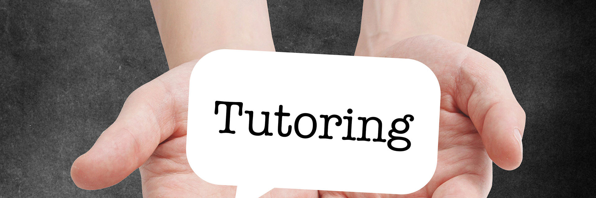 Hænder der holder et skilt med ordyden Tutoring