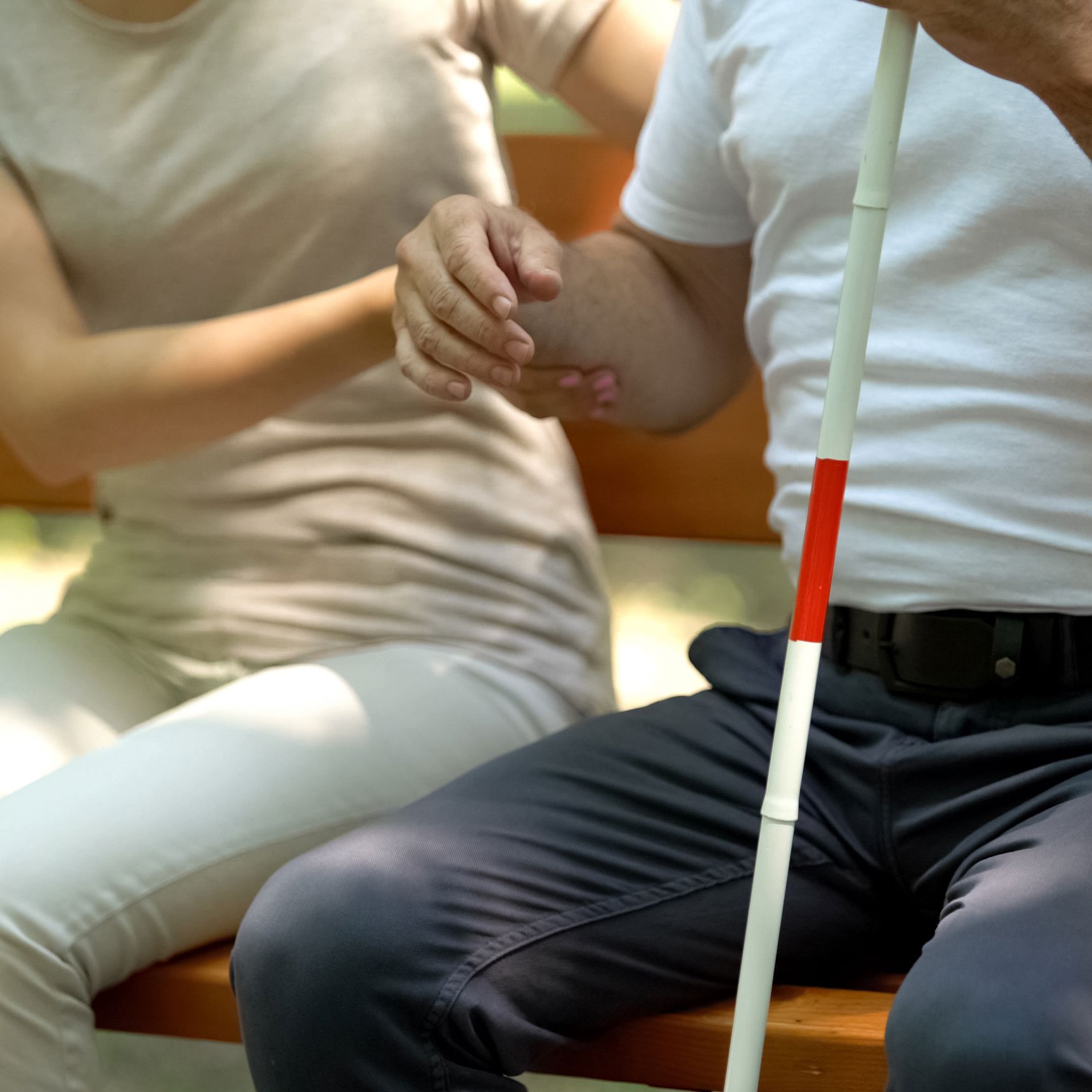 Kvinde støtter mand med blindestok