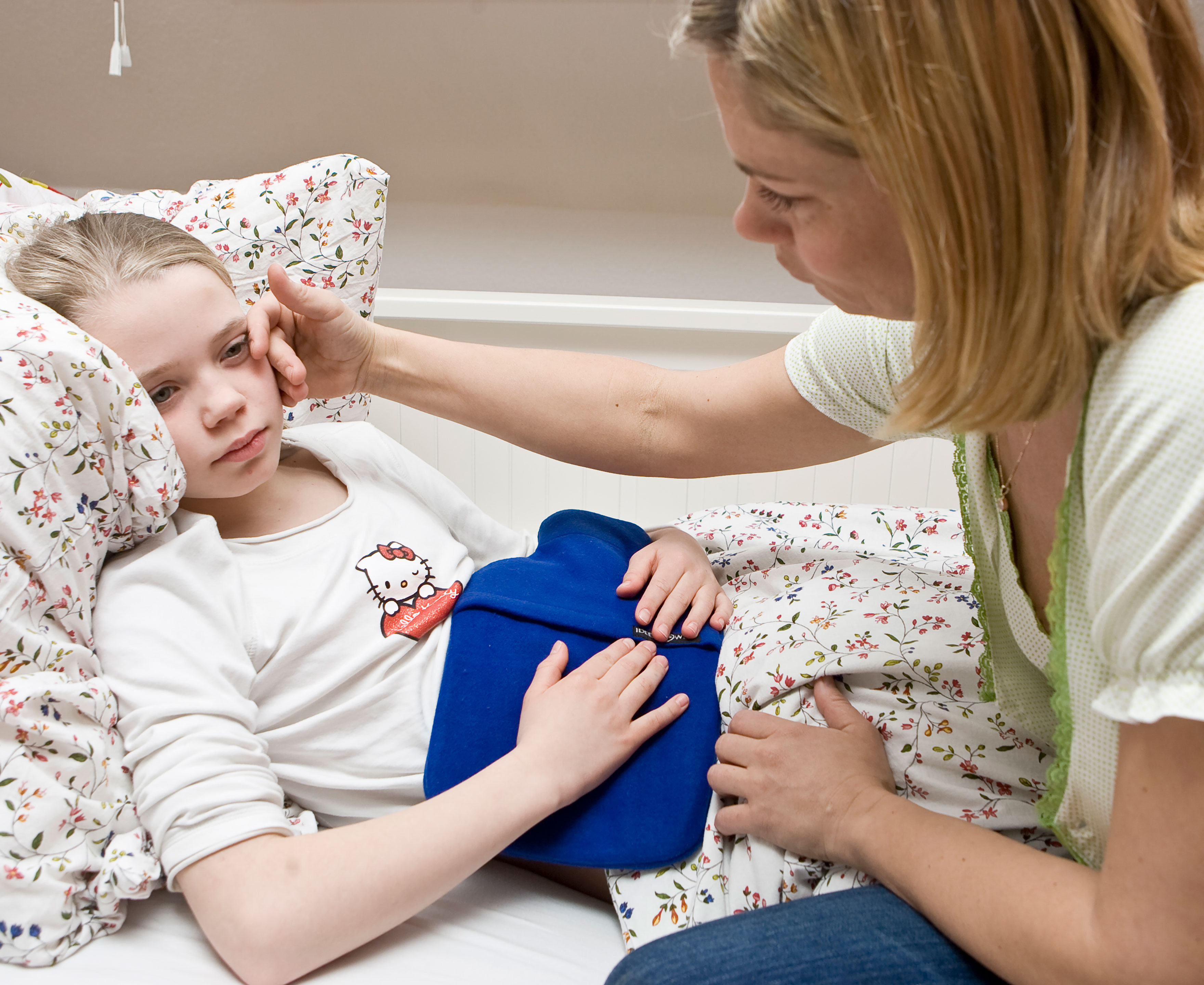 Pige der ligger i sengen med ondt i maven