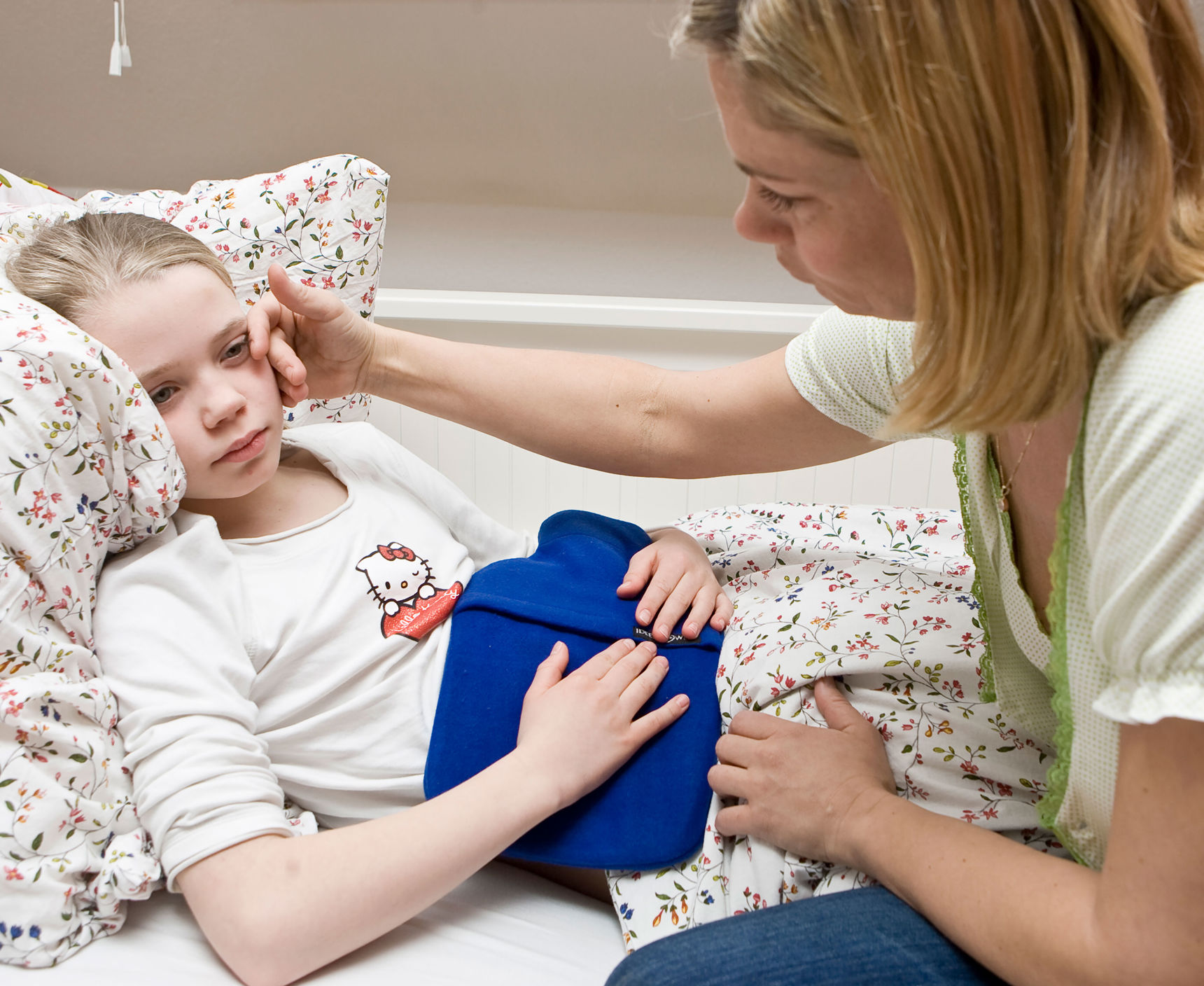 Pige der ligger i sengen med ondt i maven