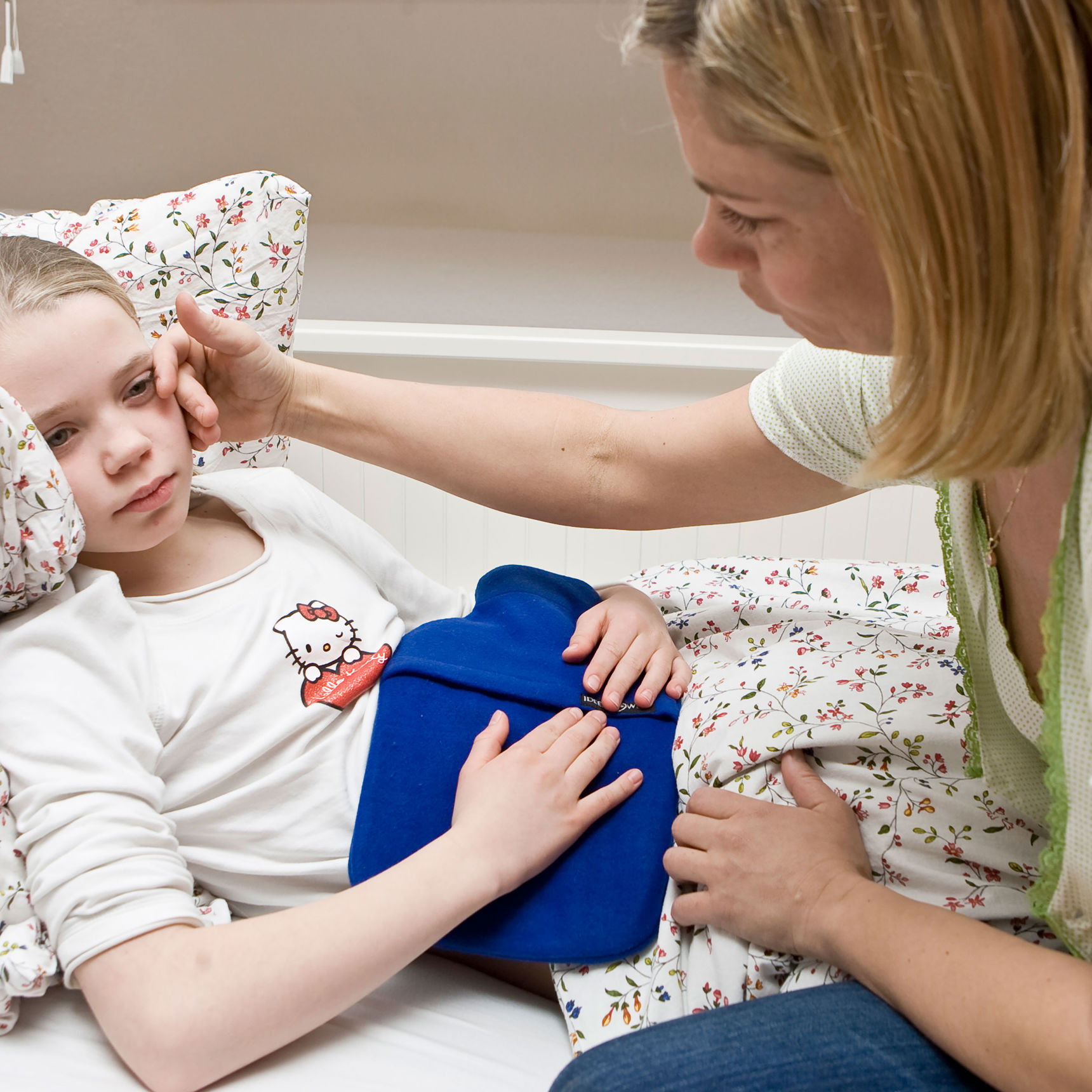 Pige der ligger i sengen med ondt i maven