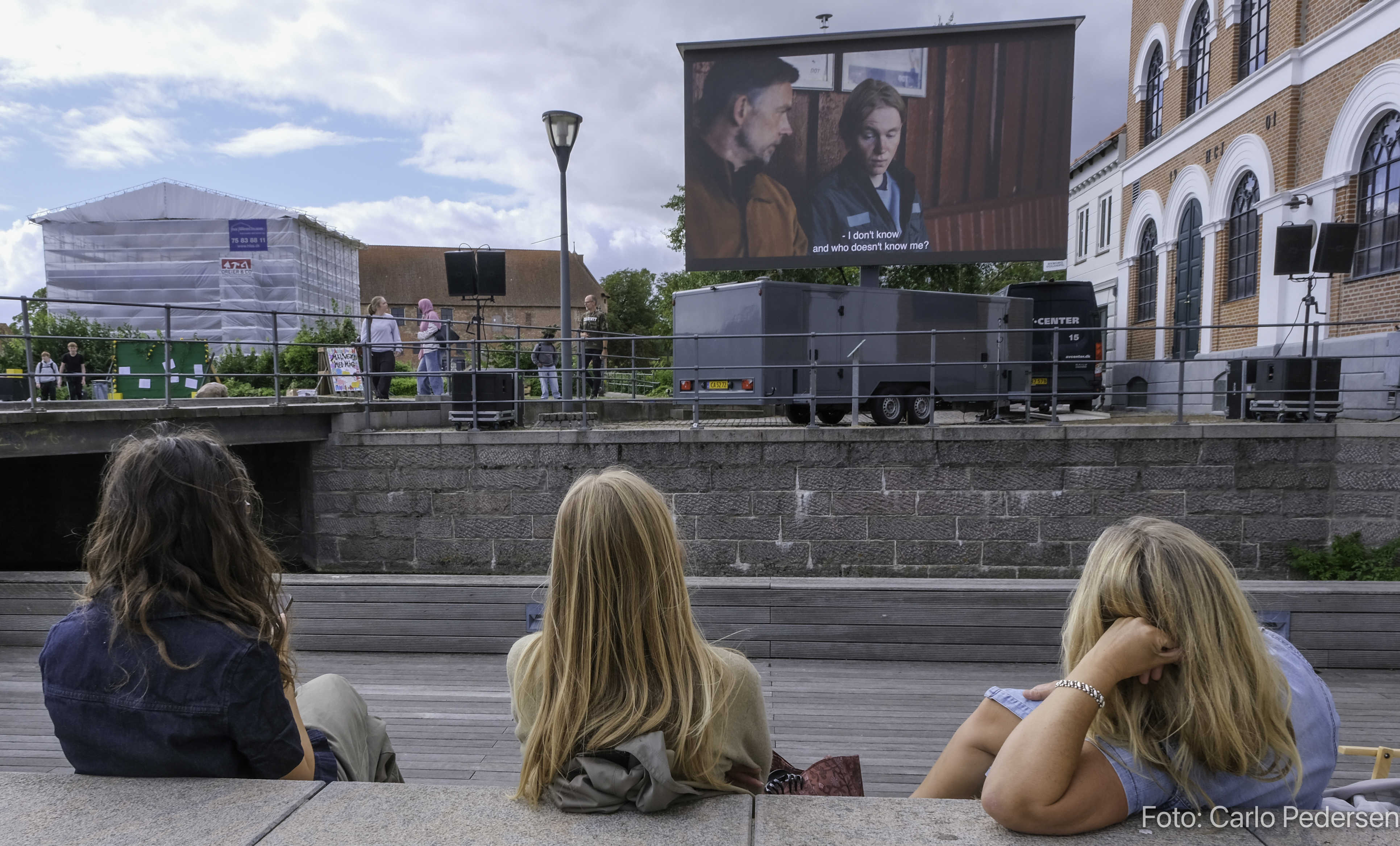 Unge mennesker ser kortfilm på amfiscenen ved Torvet