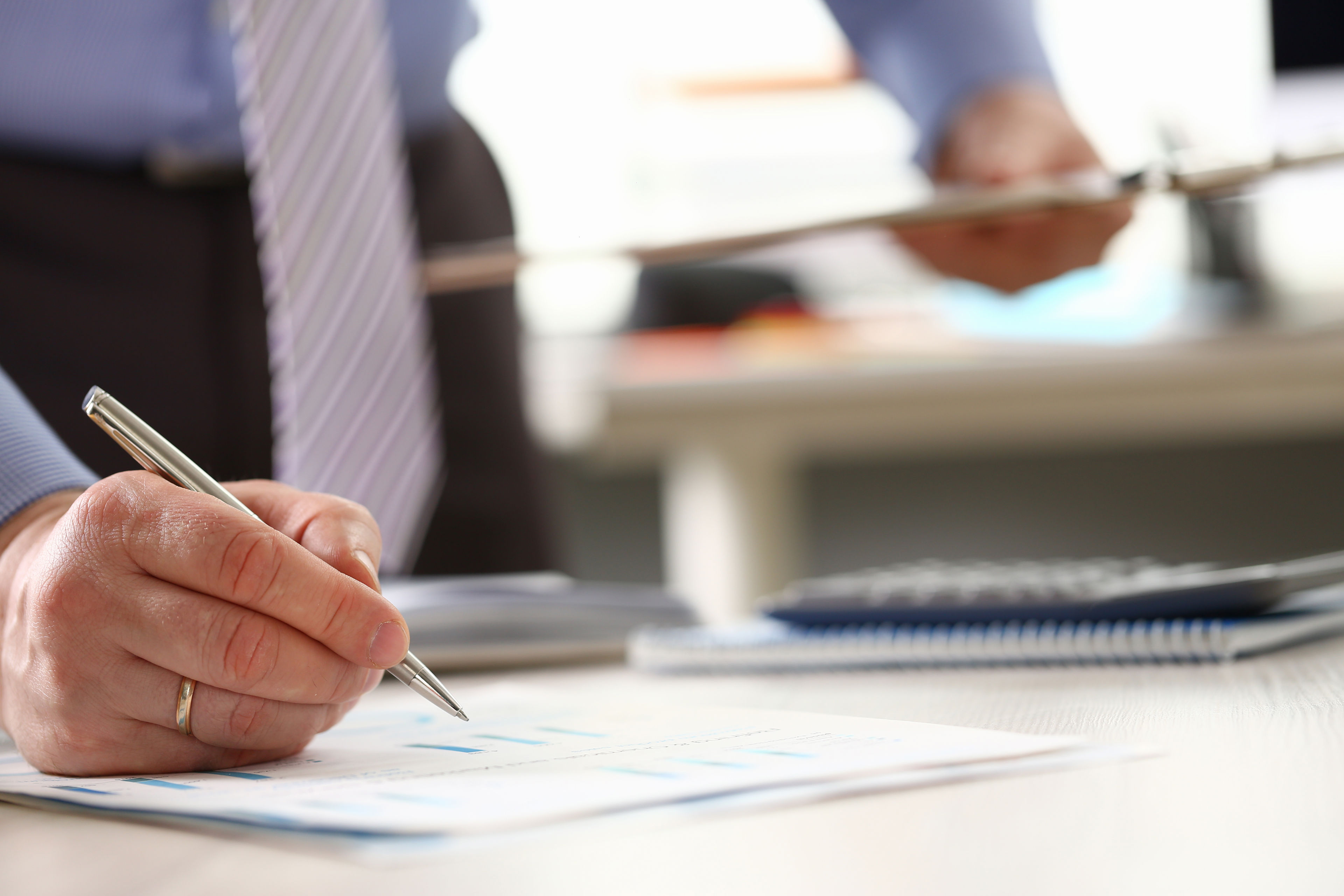 Hånd der skriver under på et dokument