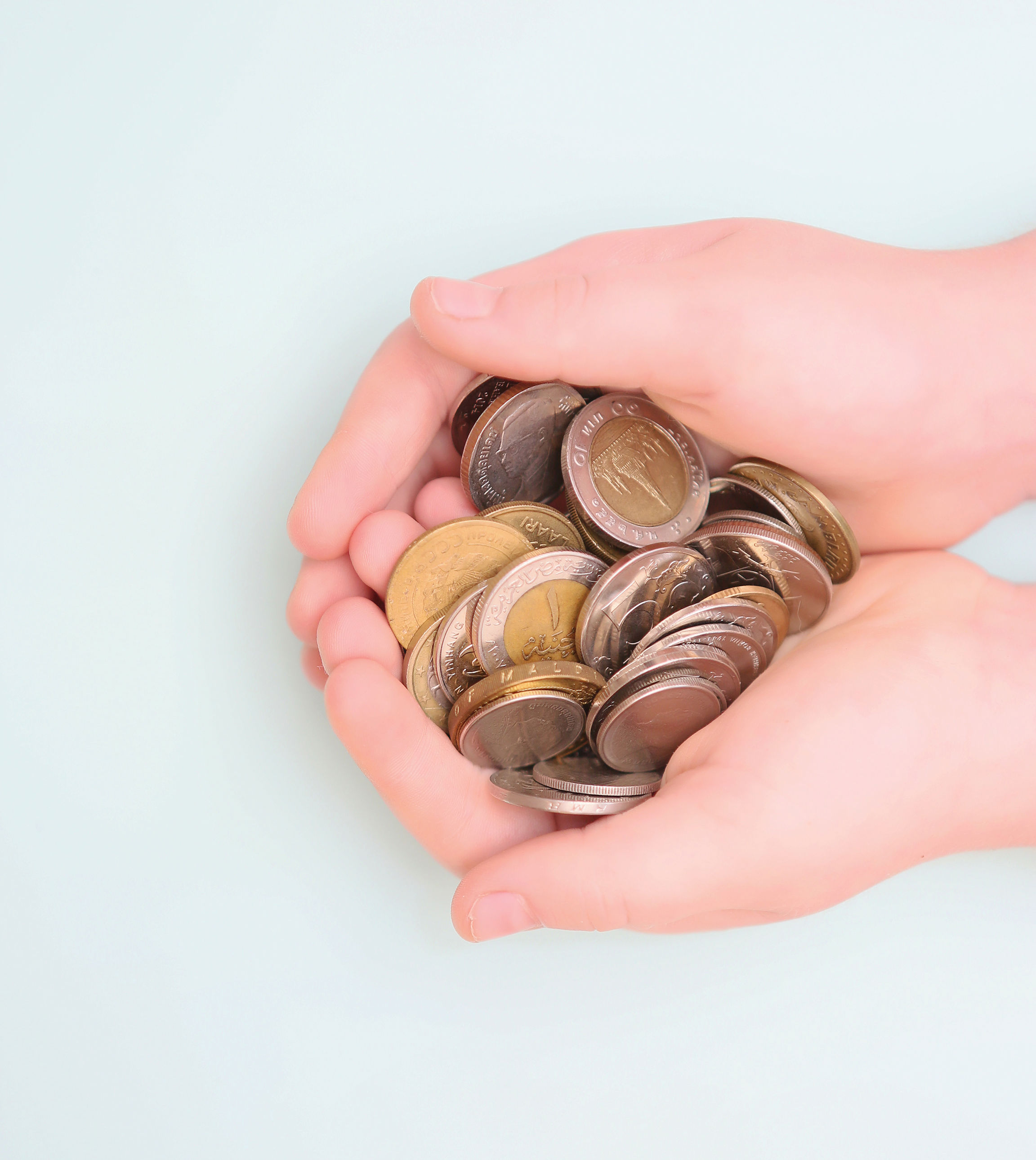 Hænder der holder en masse mønter