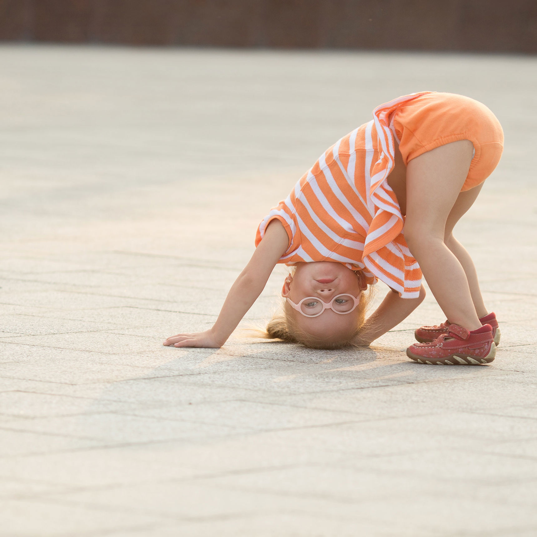 Lille pige med briller der har hovedet nedad