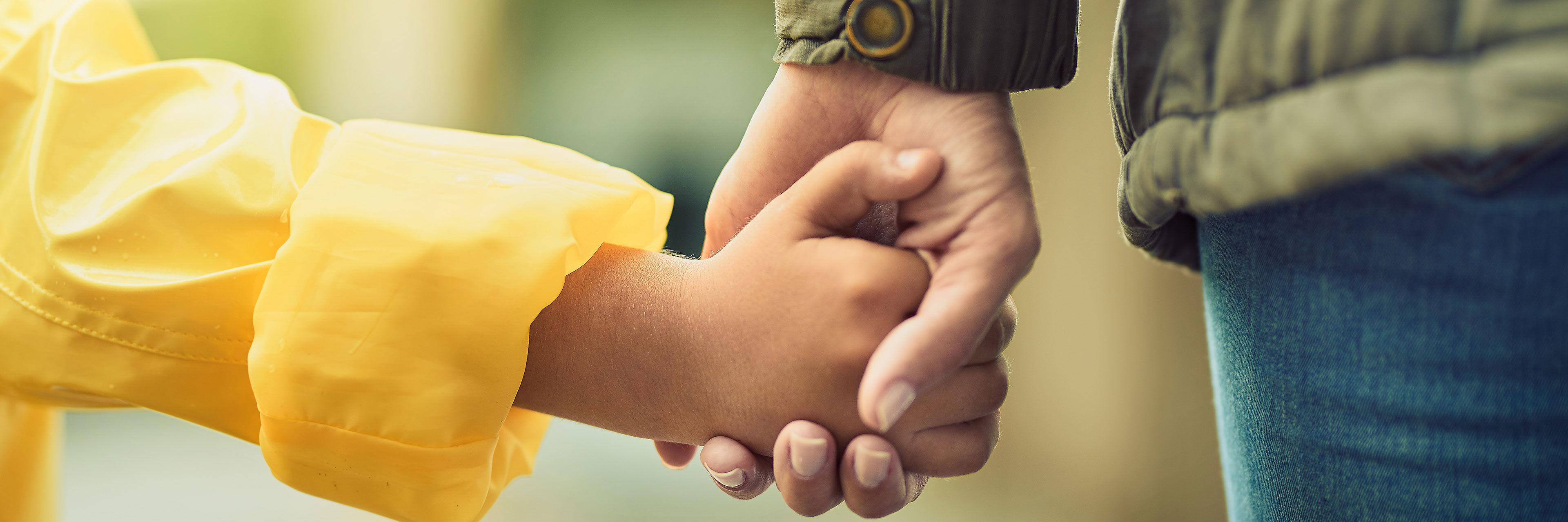 Barn- og voksenhænder der holder hinanden i hånden