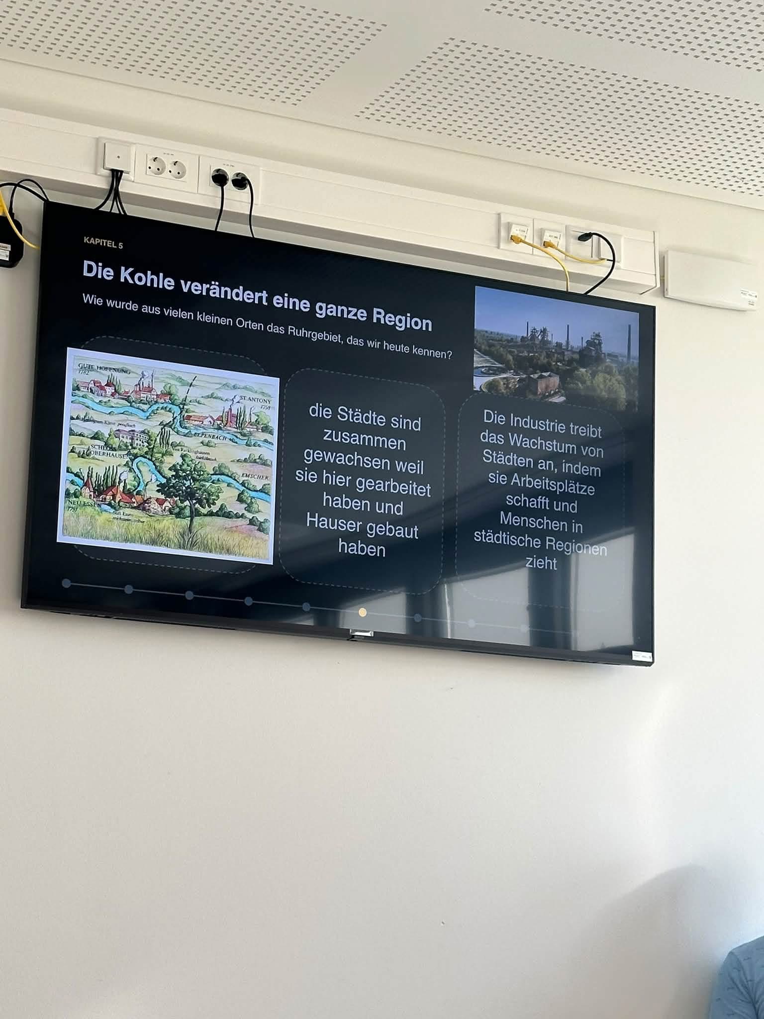 En TV skærm på en væg i et mødelokale