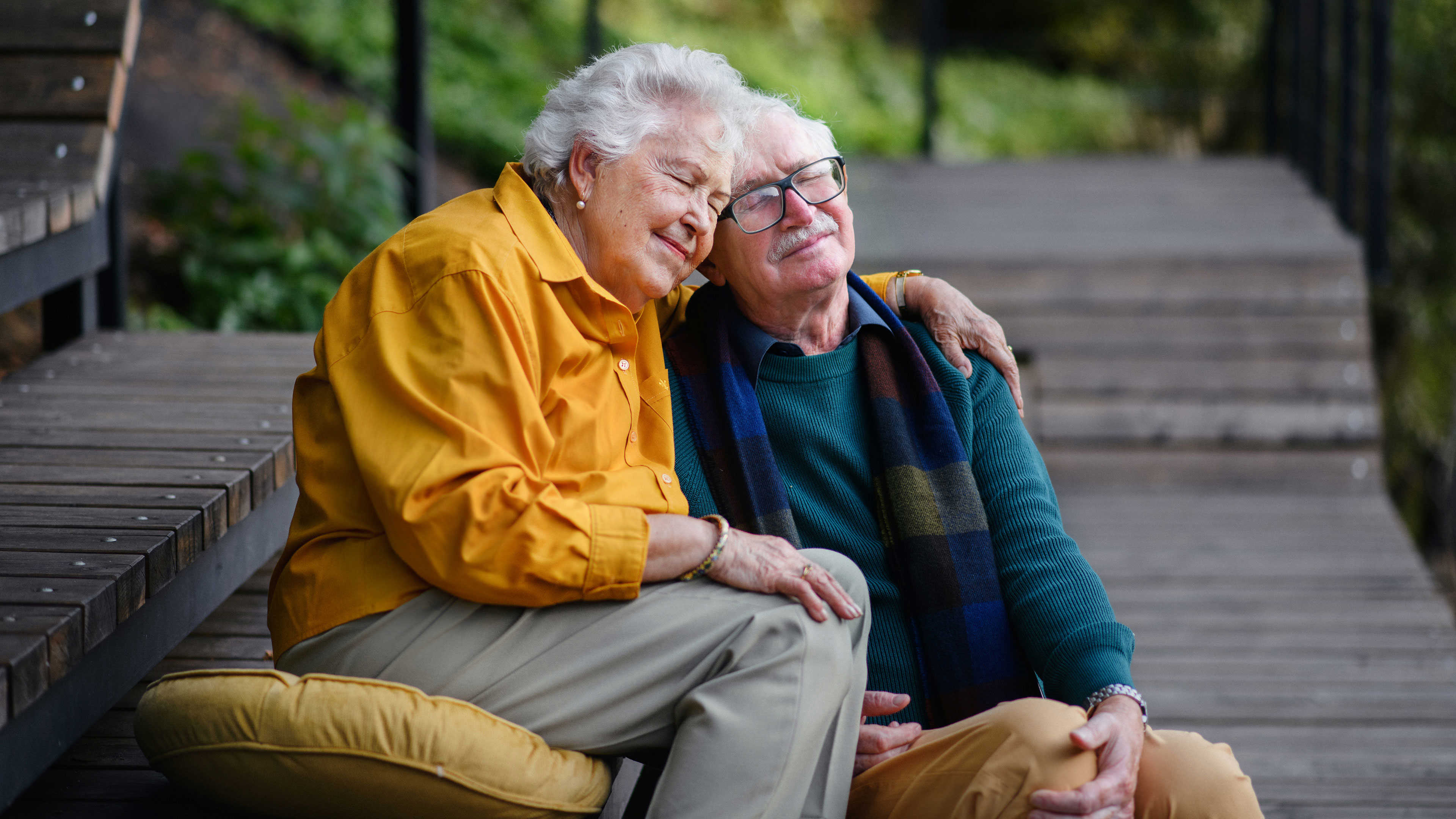 To ældre mennesker der krammer med lukkede øjne