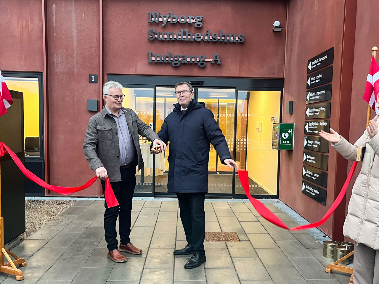 Kenneth Muhs og Jan Reimer Christiansen klipper den røde snor og åbner Nyborg Sundhedhus