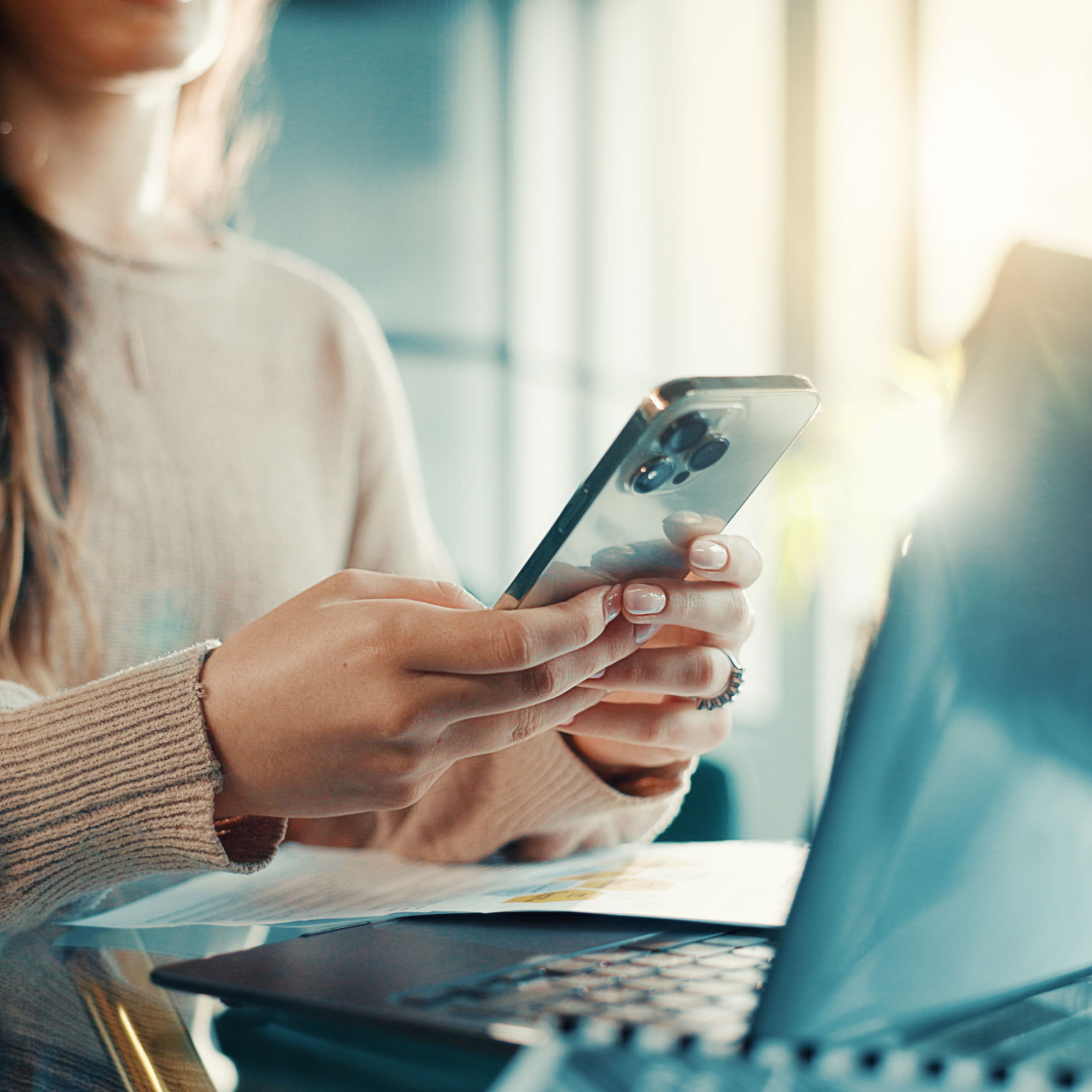 Kvinde der sidder med pc og mobiltelefon