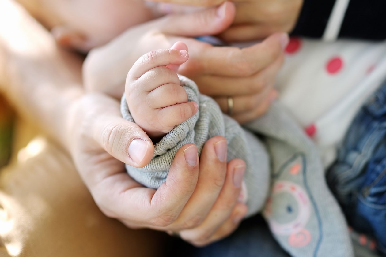 Voksenhænder der holder en babyhånd