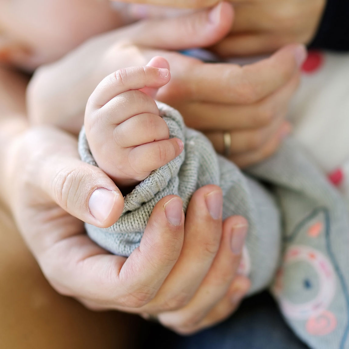Voksenhænder der holder en babyhånd