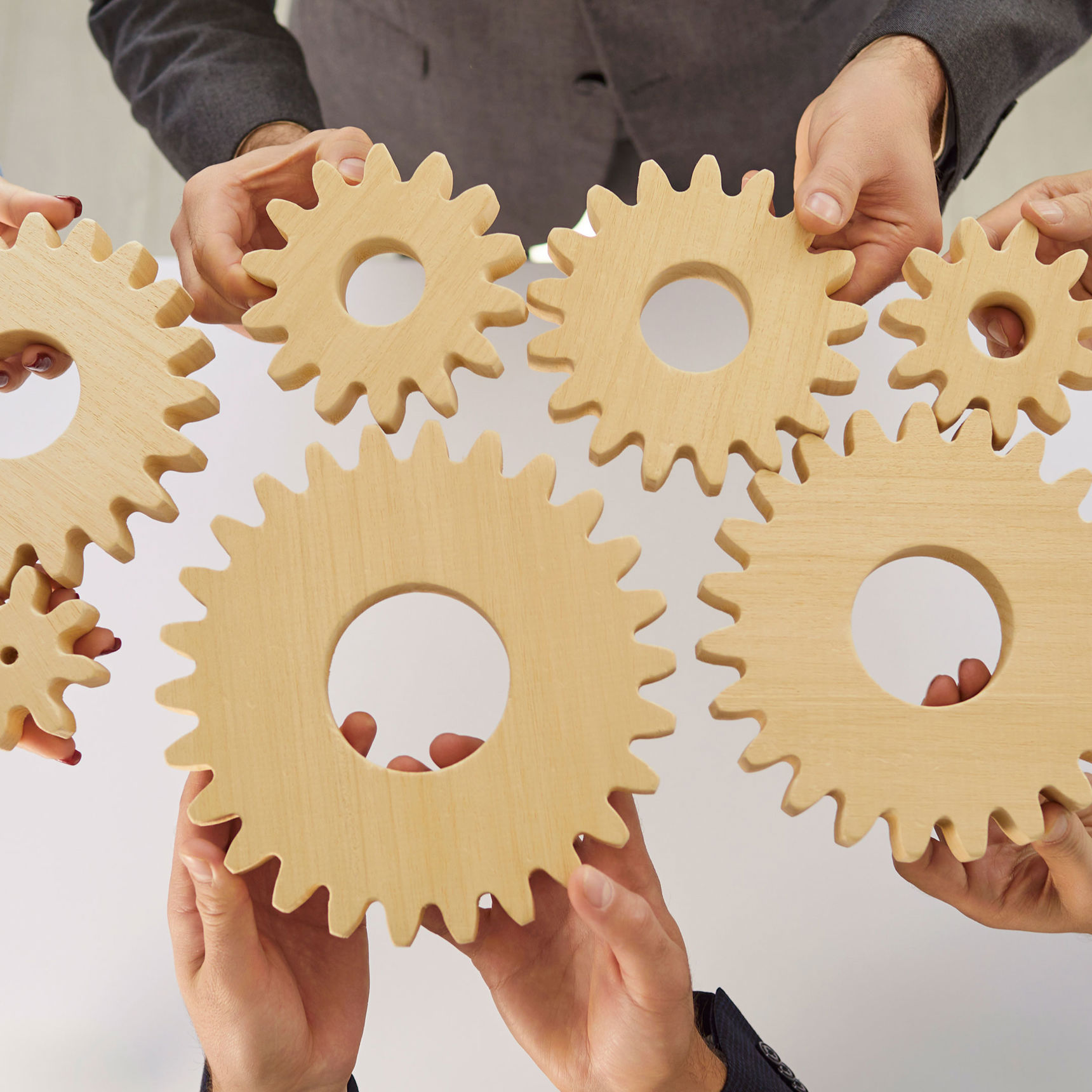 Hænder der holder tandhjul mod hinanden