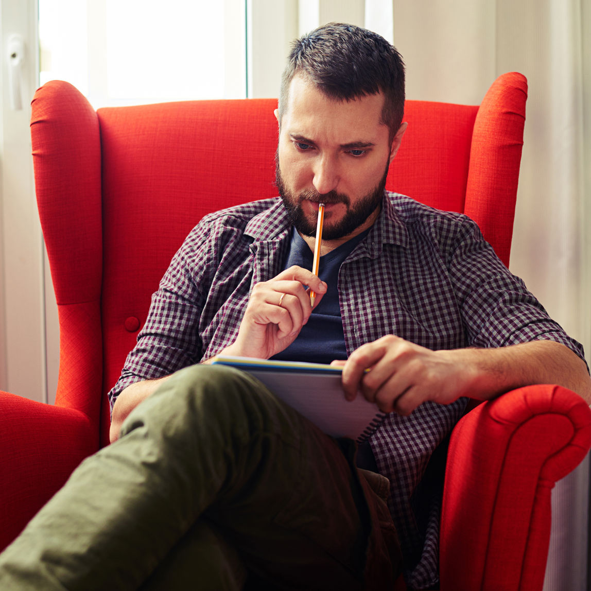 Mand sidder og kigger på en notesblok