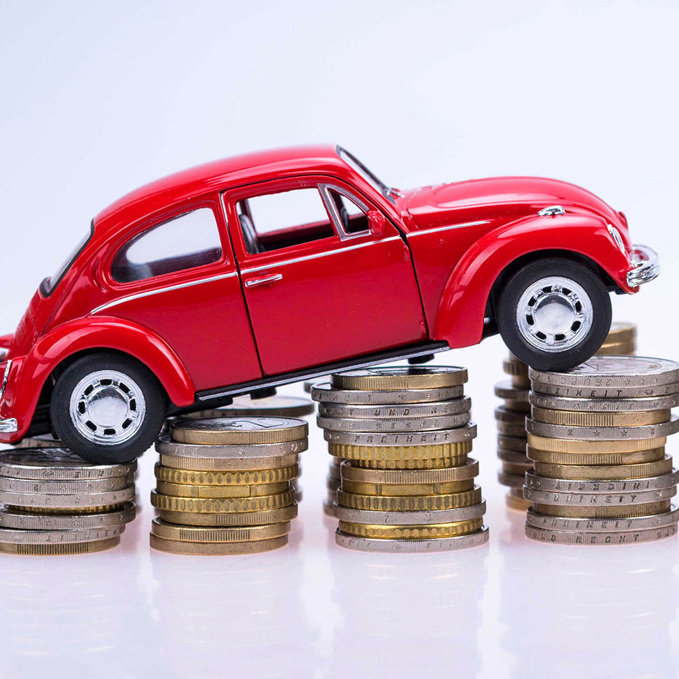En legetøjsbil sat på en stak mønter