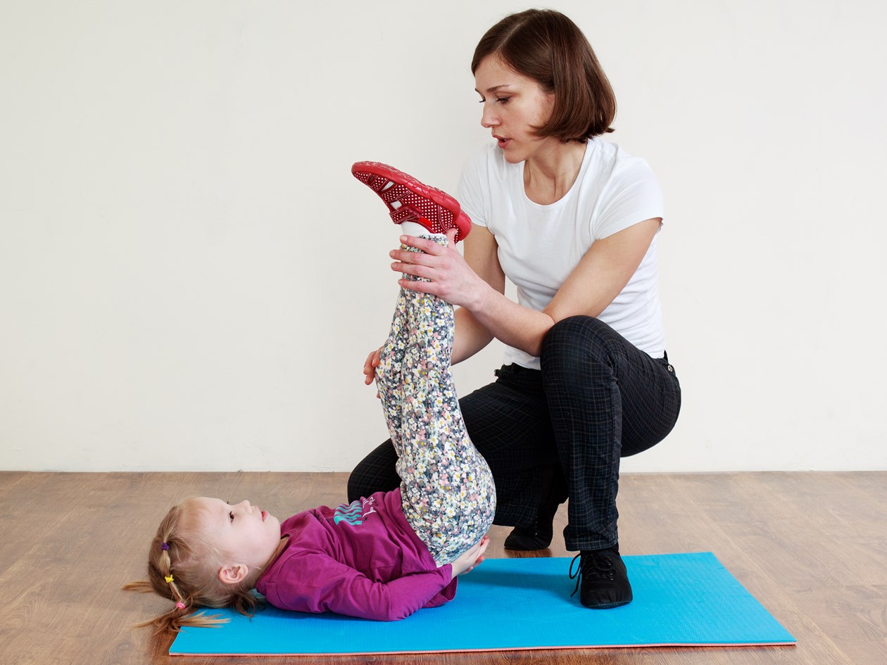 Barn og fysioterapeut der træner