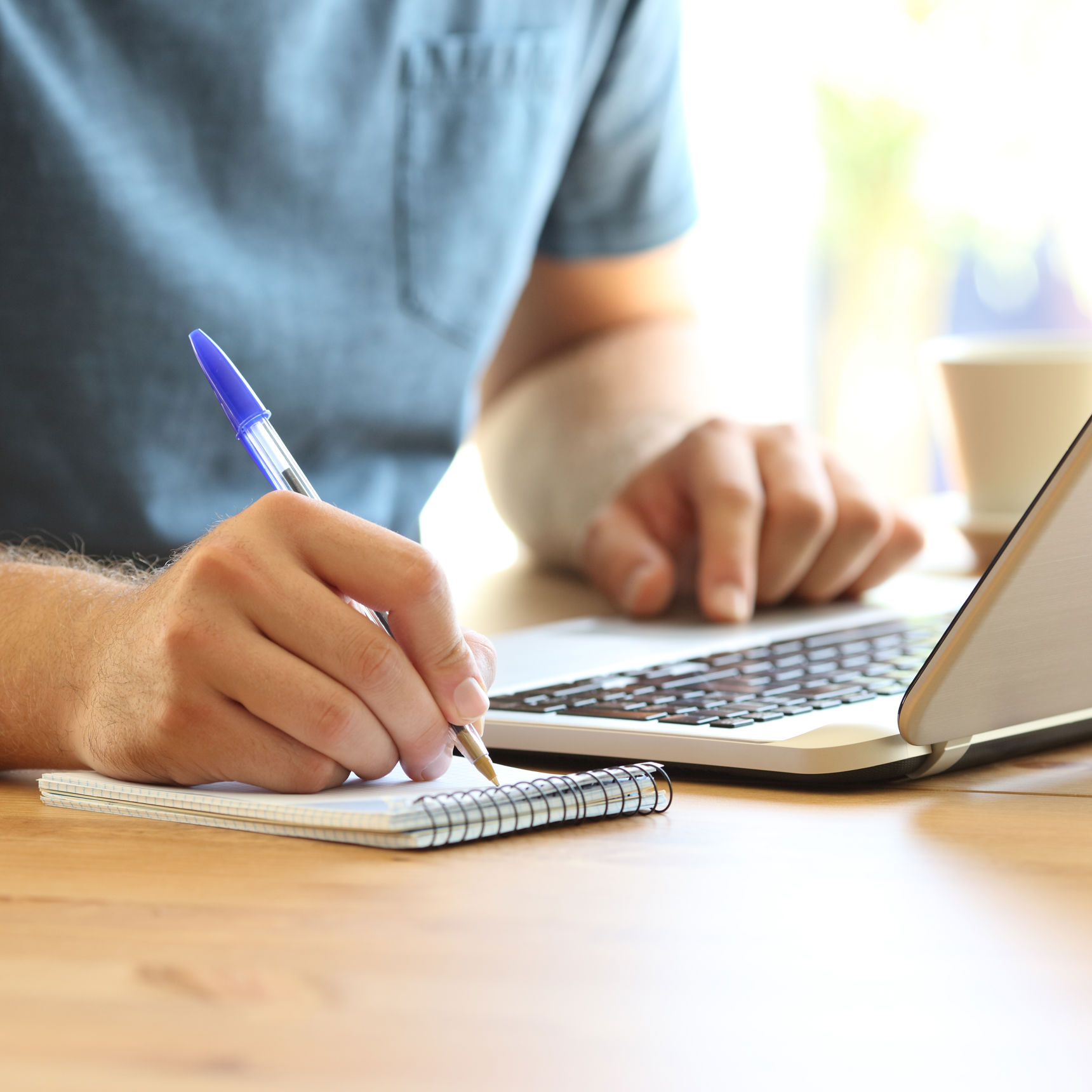 Mand der noterer på en blok