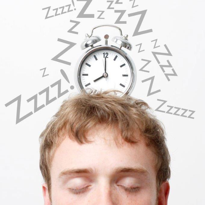 Ansigt med z'er og vækkeur i en bobbel over hovedet