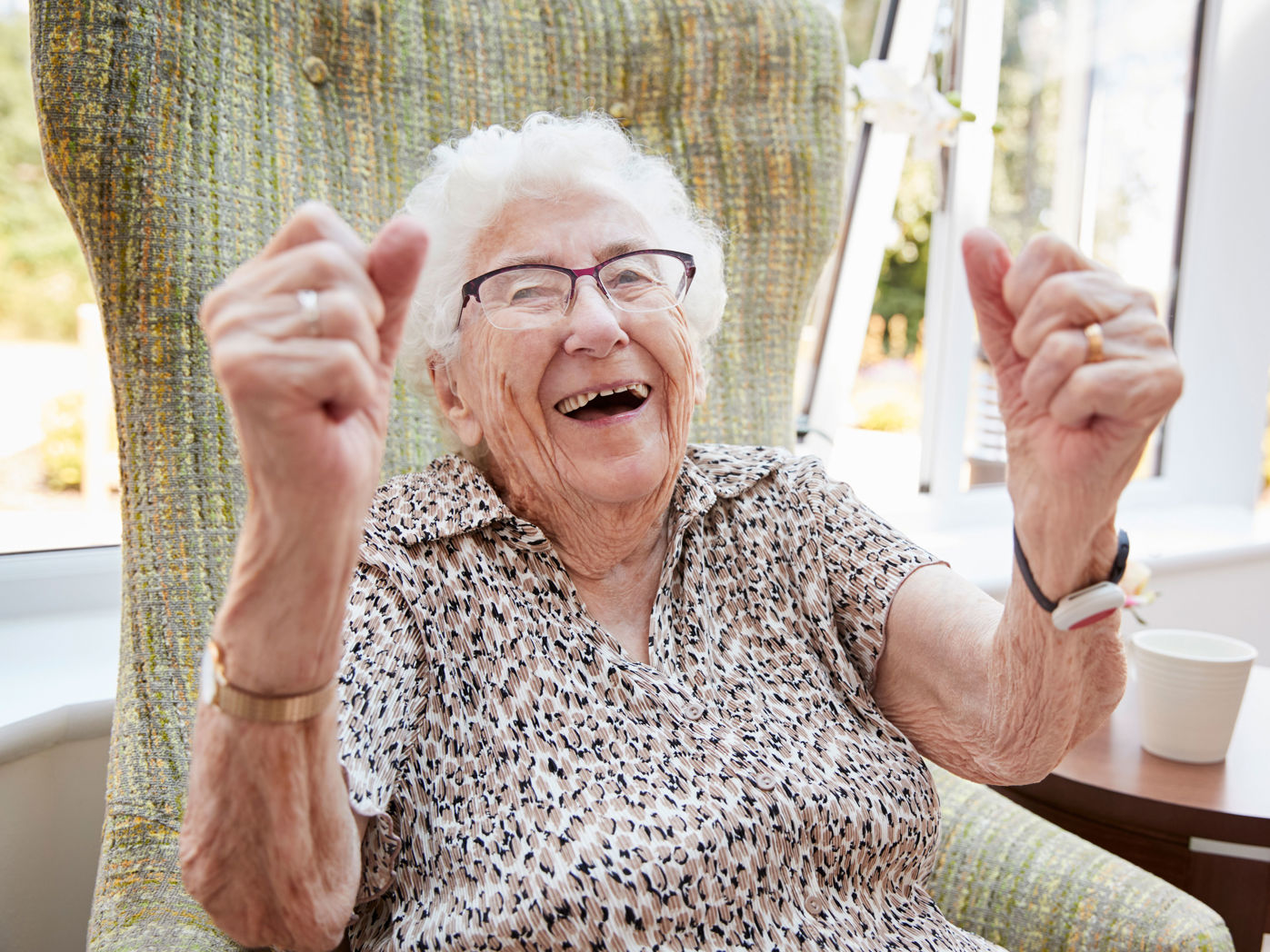 En meget ældre dame der jubler i sin stol