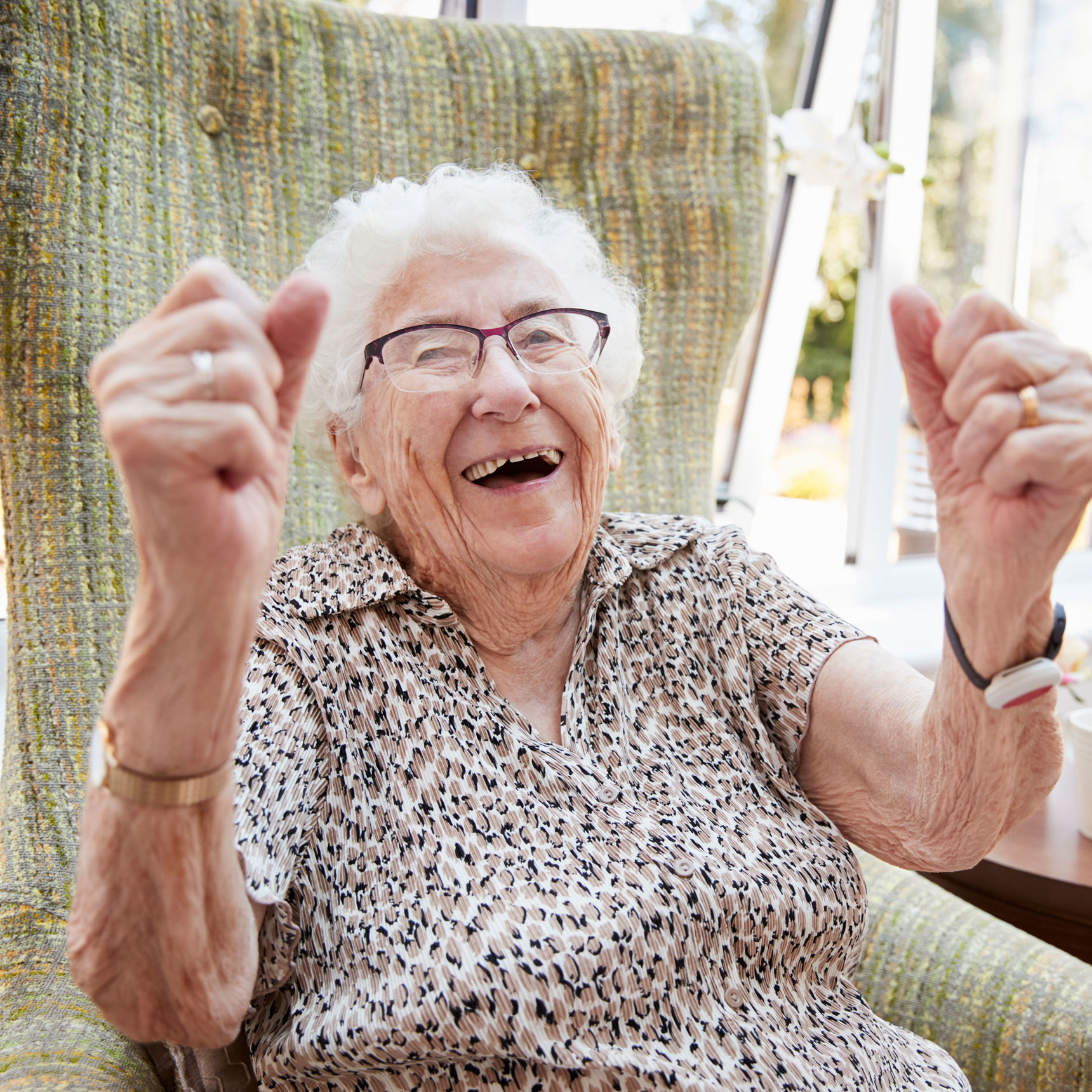 En meget ældre dame der jubler i sin stol