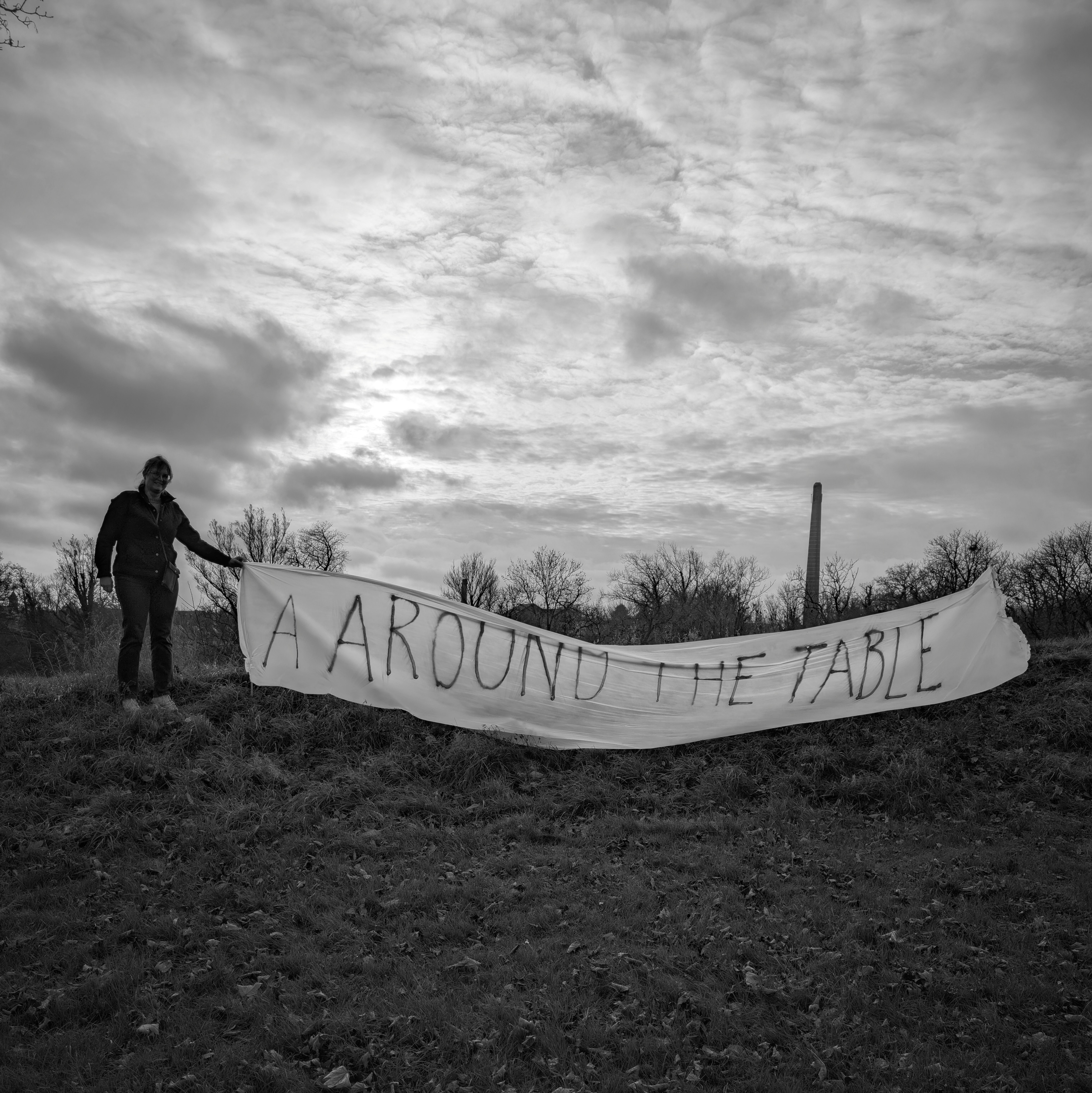 Banner i det fri med ordlyden ' A AROUND THE TABLE'