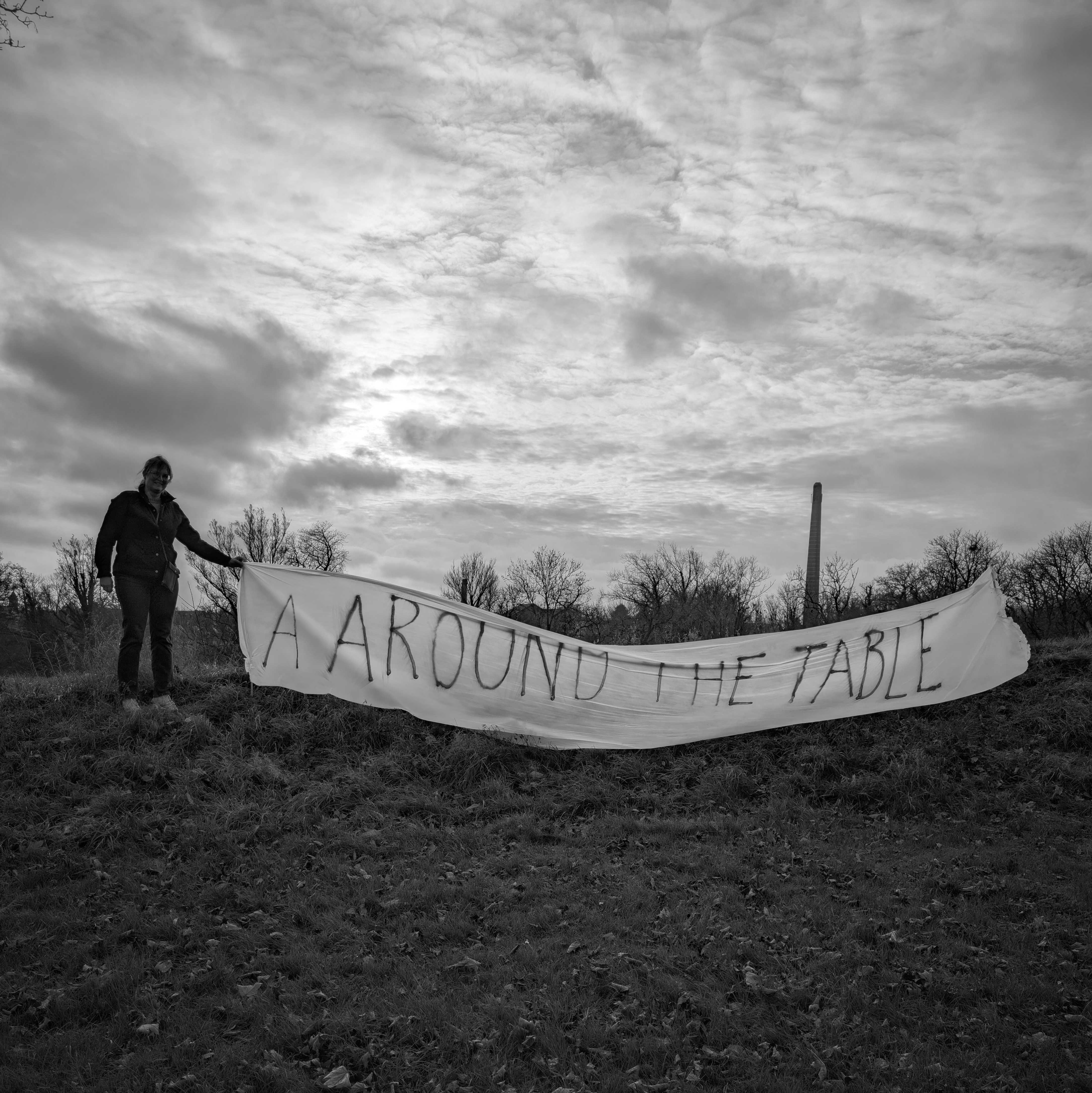 Banner i det fri med ordlyden ' A AROUND THE TABLE'
