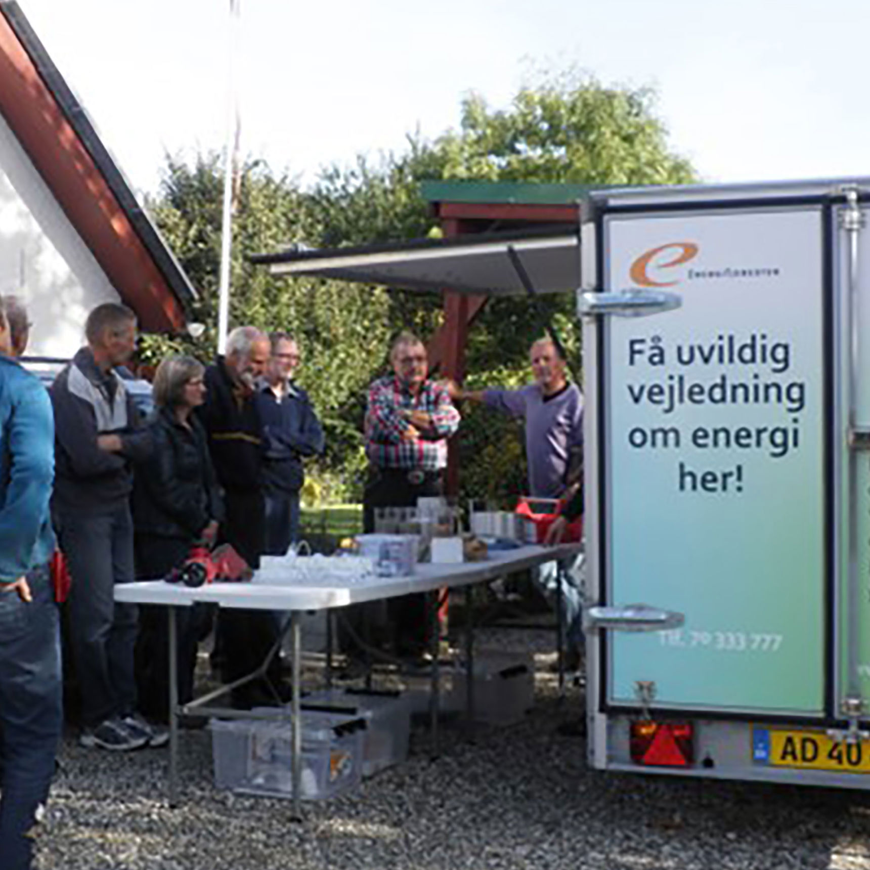 Folk der står udendørs og får vejledning om energi