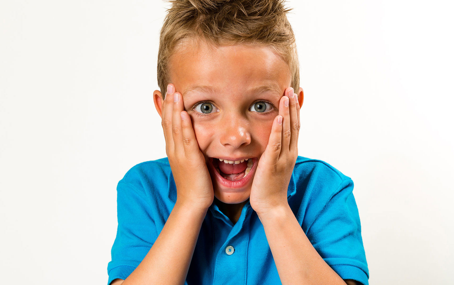 Dreng med åben mund og hænder på kinderne