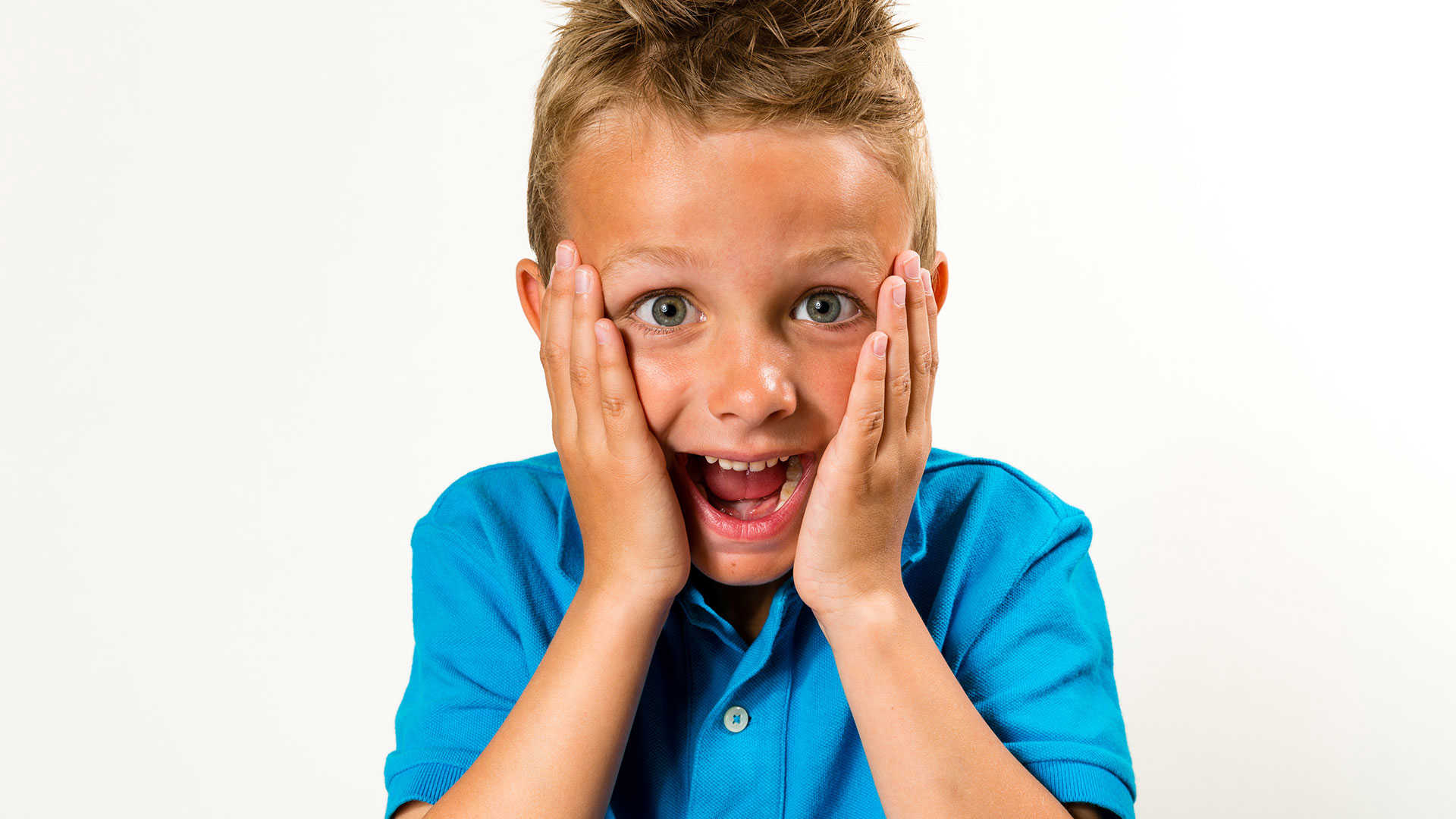 Dreng med åben mund og hænder på kinderne