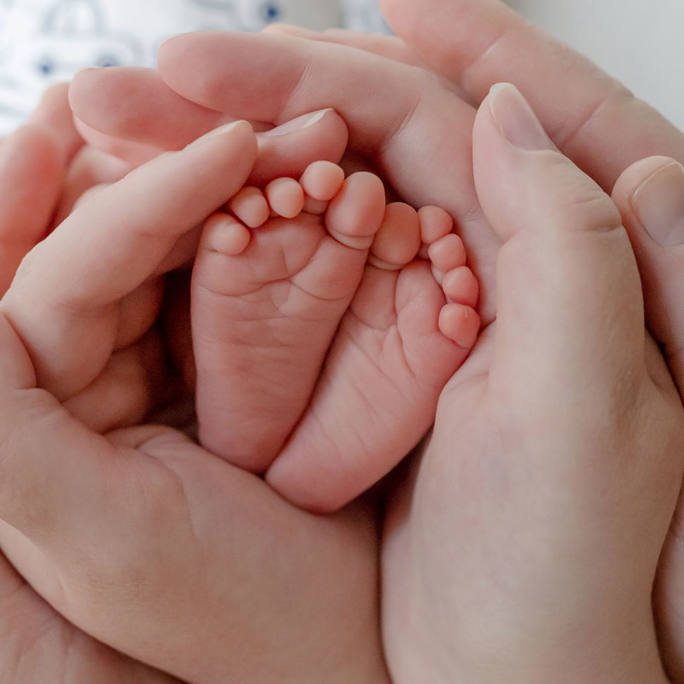Hænder der holder barnefødder