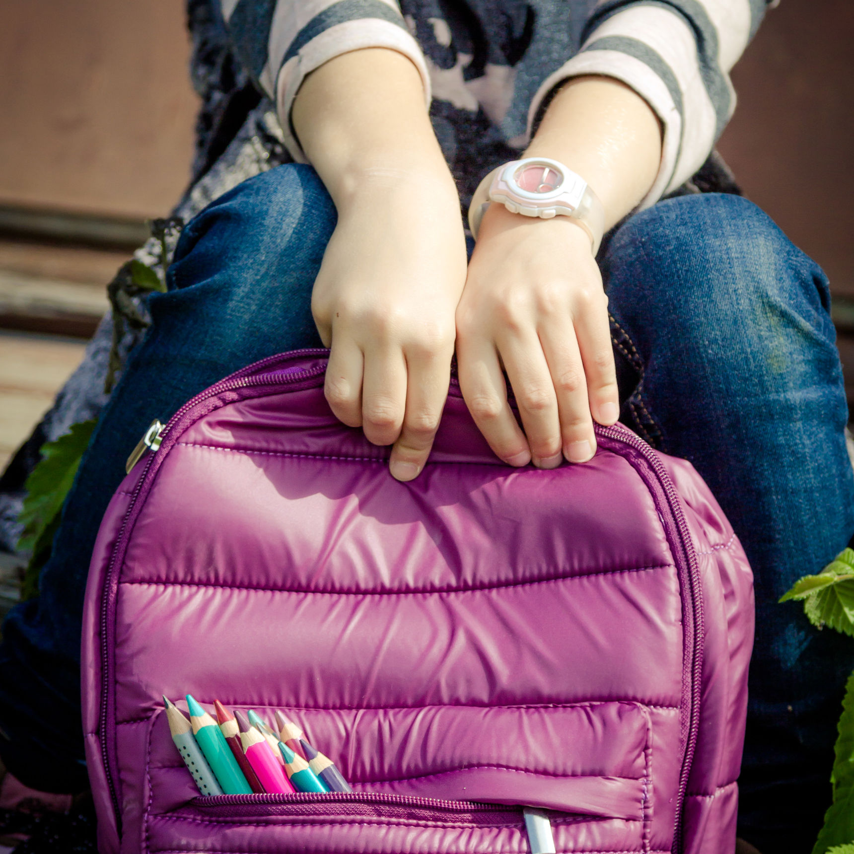 Pige der sidder med sin skoletaske