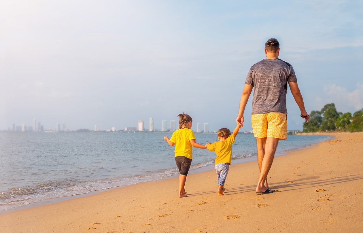 Far og to børn på stranden