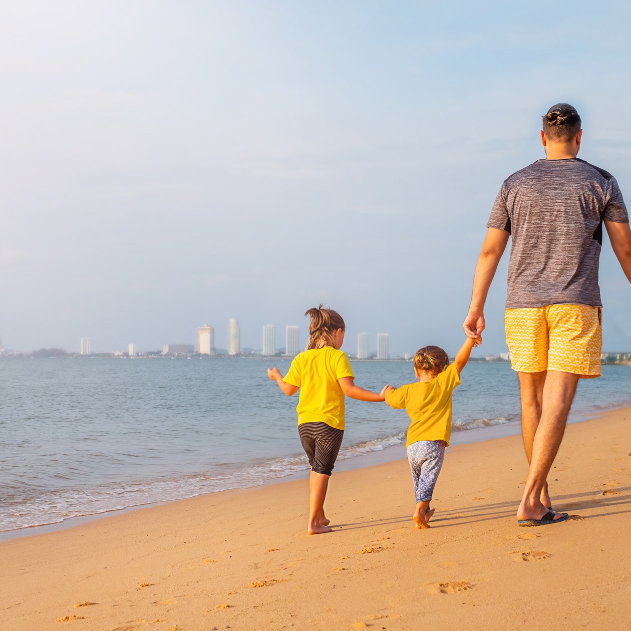 Far og to børn på stranden