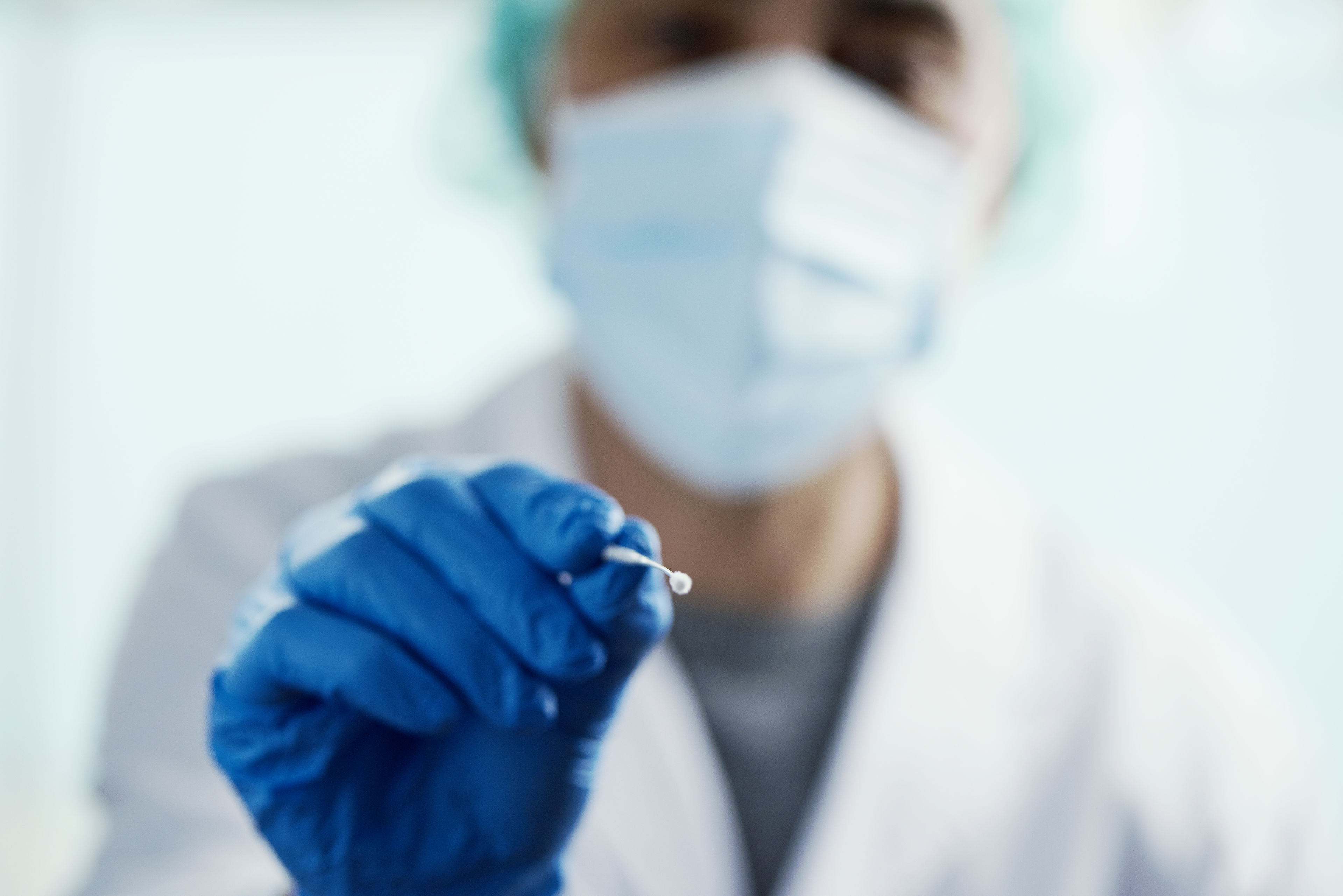 Mand med mundbind og podepind i hånden