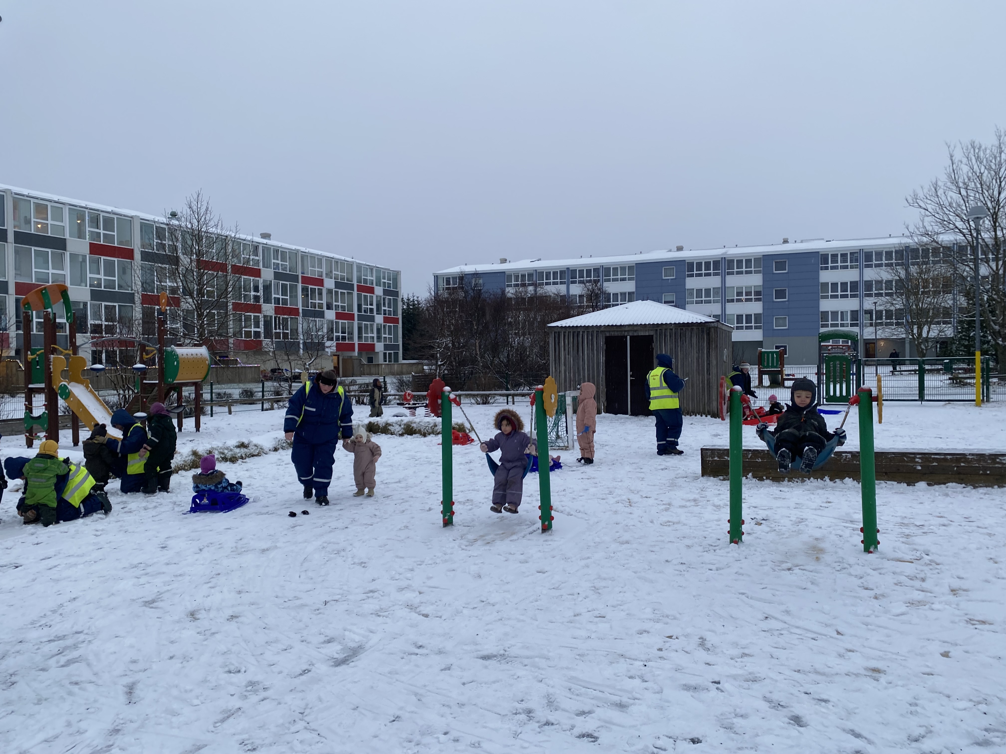 Børn der leger på en legeplads i snevejr i Island
