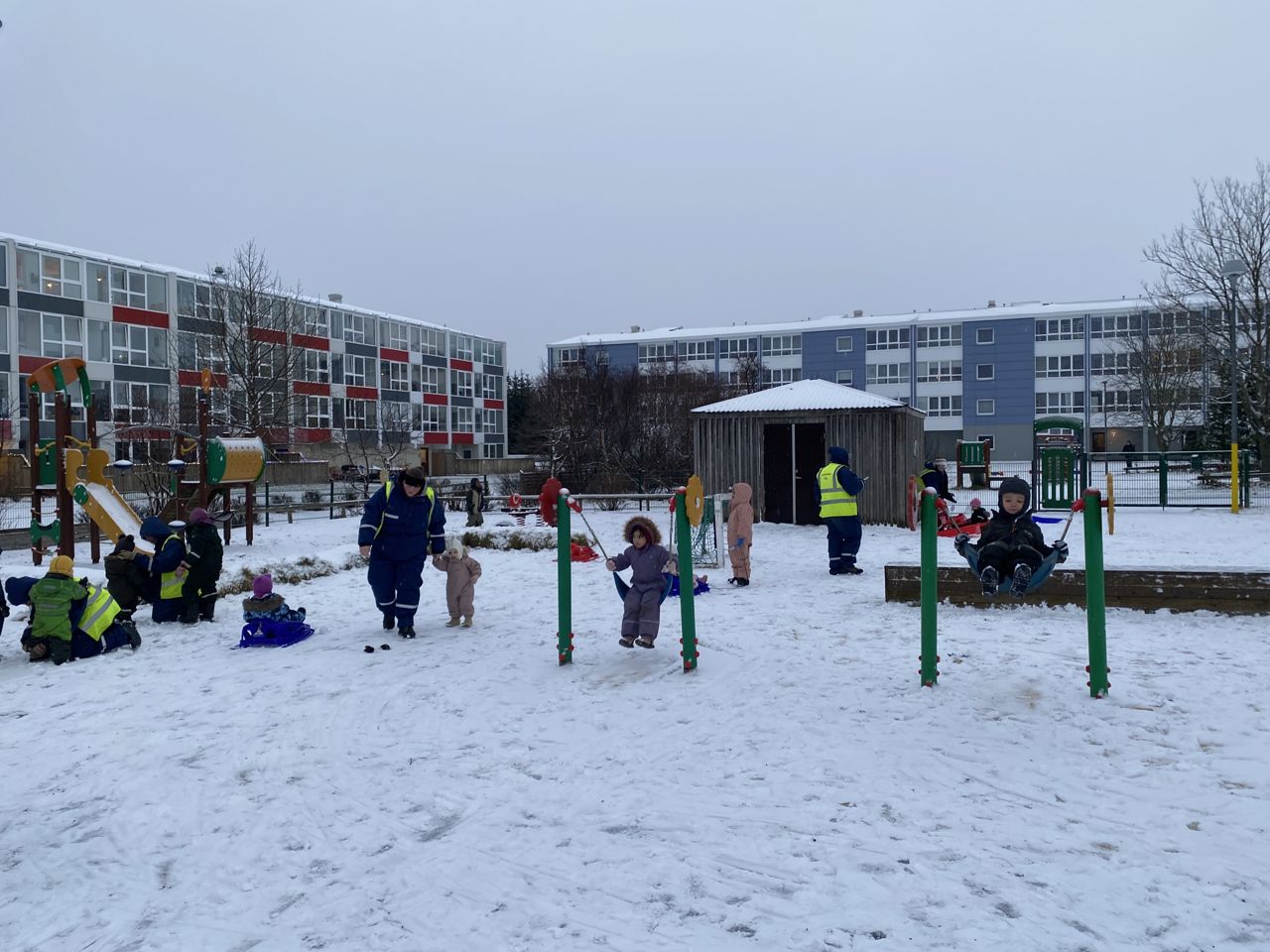 Børn der leger på en legeplads i snevejr i Island