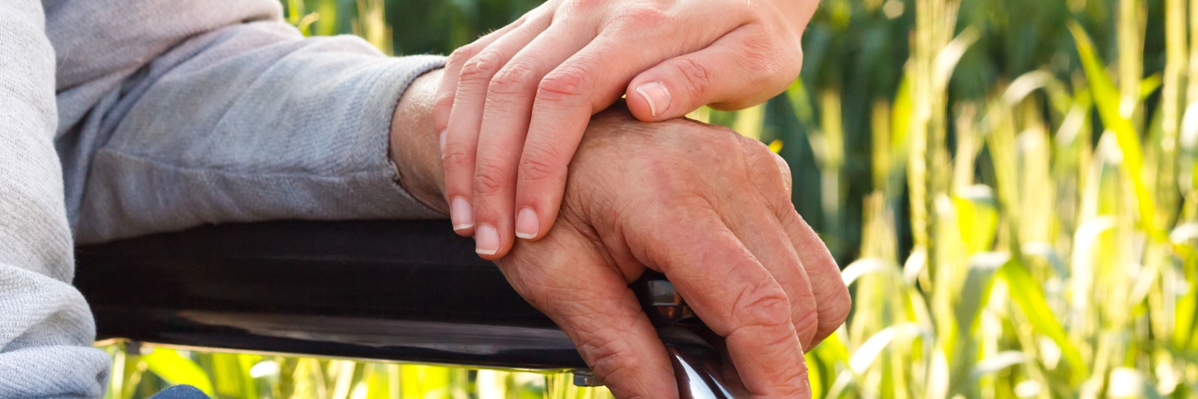 To der holder hænder - den ene i kørestol