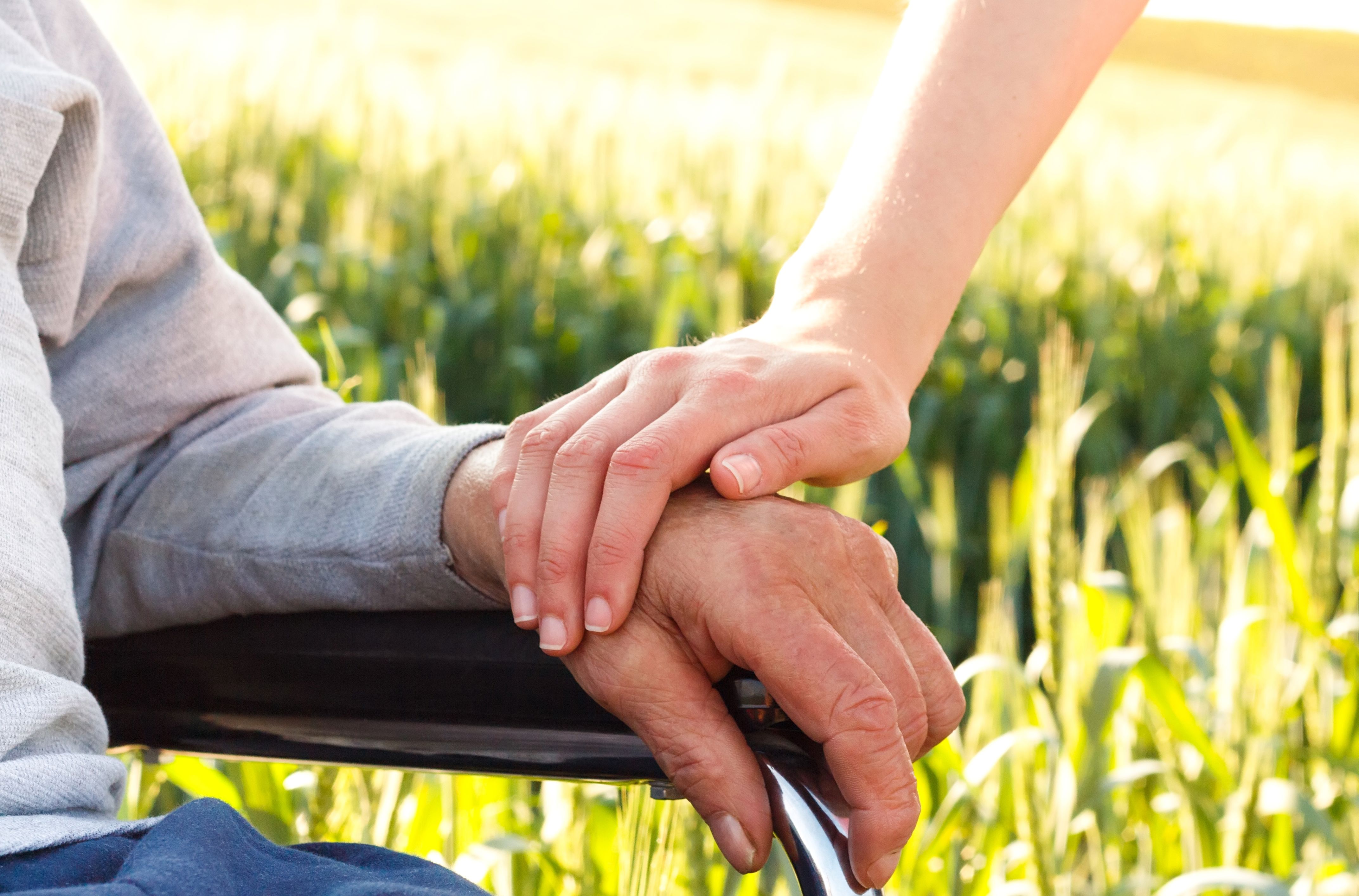 To der holder hænder - den ene i kørestol